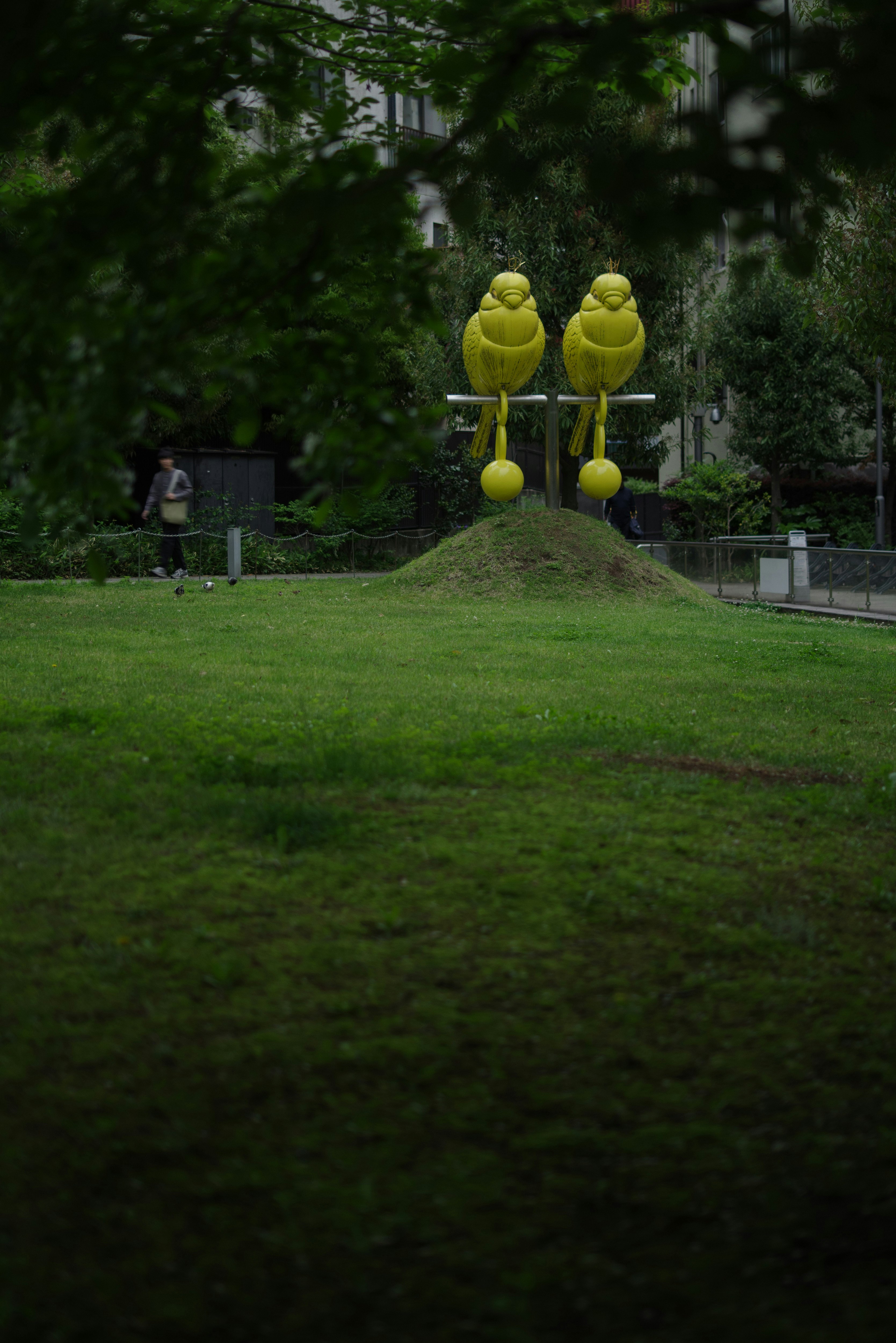 sculpture jaune en forme de ballon sur une pelouse de parc