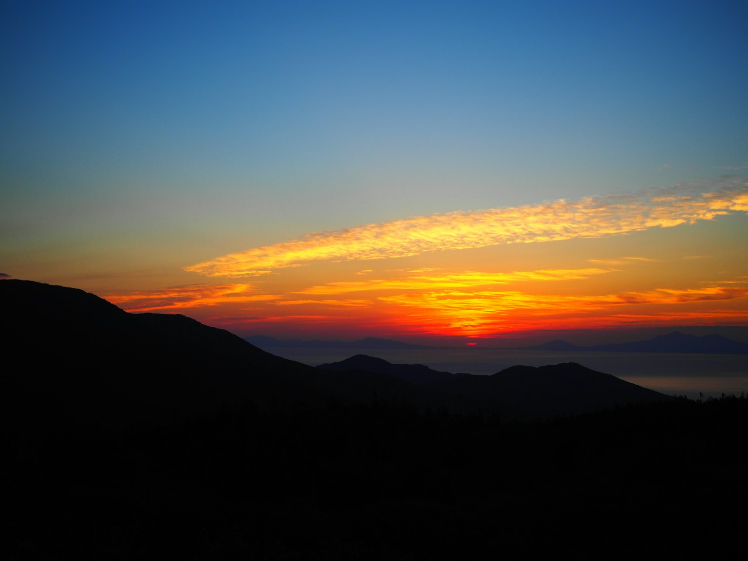 Bellissimo paesaggio al tramonto con montagne e cielo blu armonioso