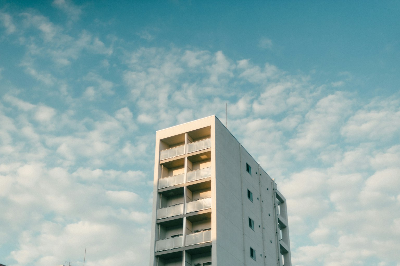 Bâtiment blanc sous un ciel bleu avec des nuages