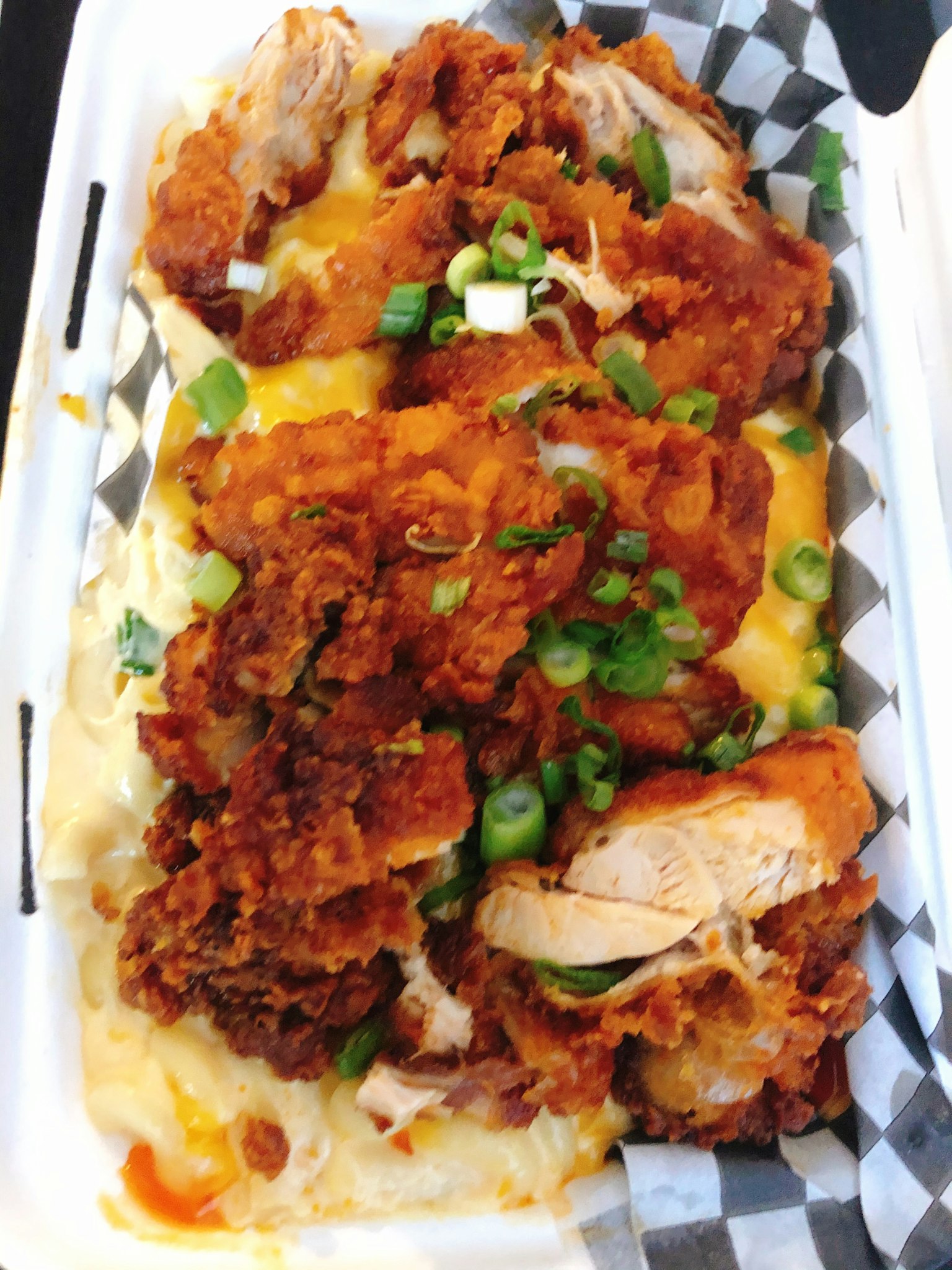 치킨과 치즈, 파가 얹힌 음식이 담긴 용기