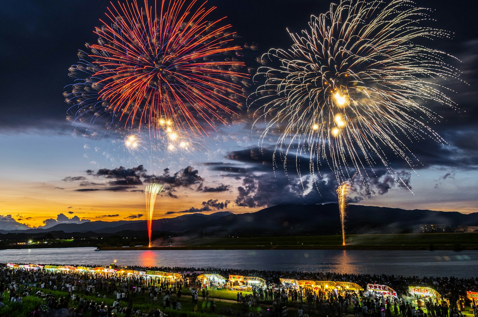 Magnifique scène d'un feu d'artifice au crépuscule avec des spectateurs