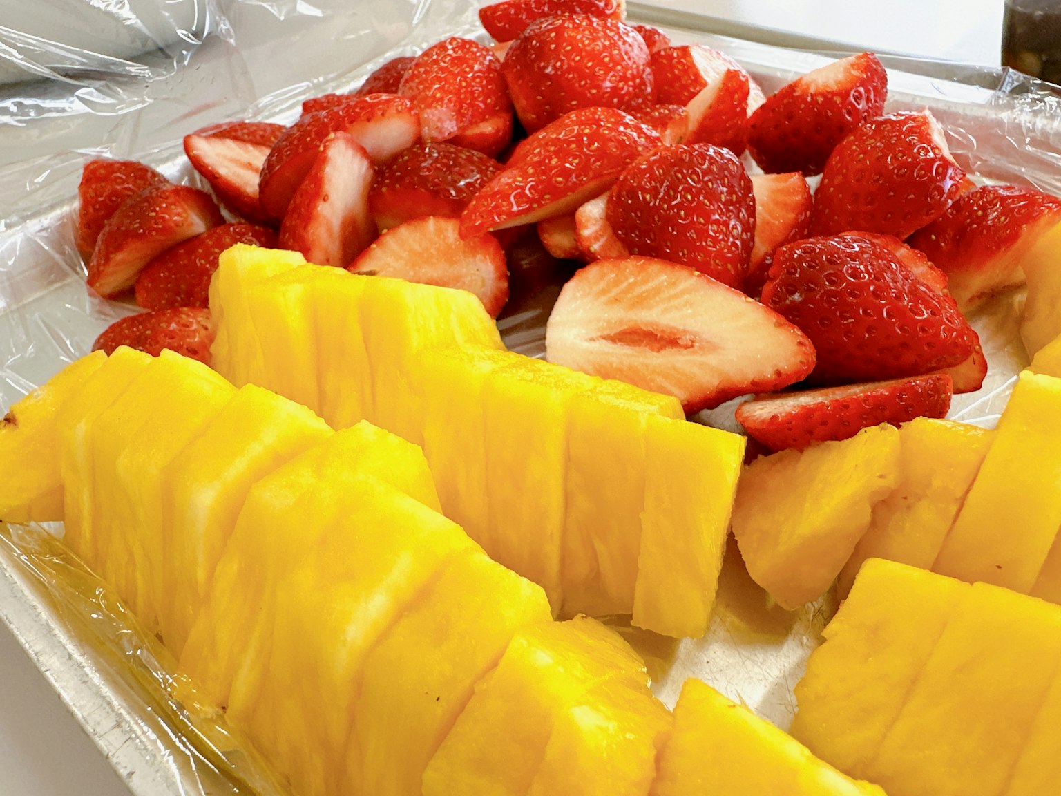 Platte mit geschnittenem Ananas und Erdbeeren