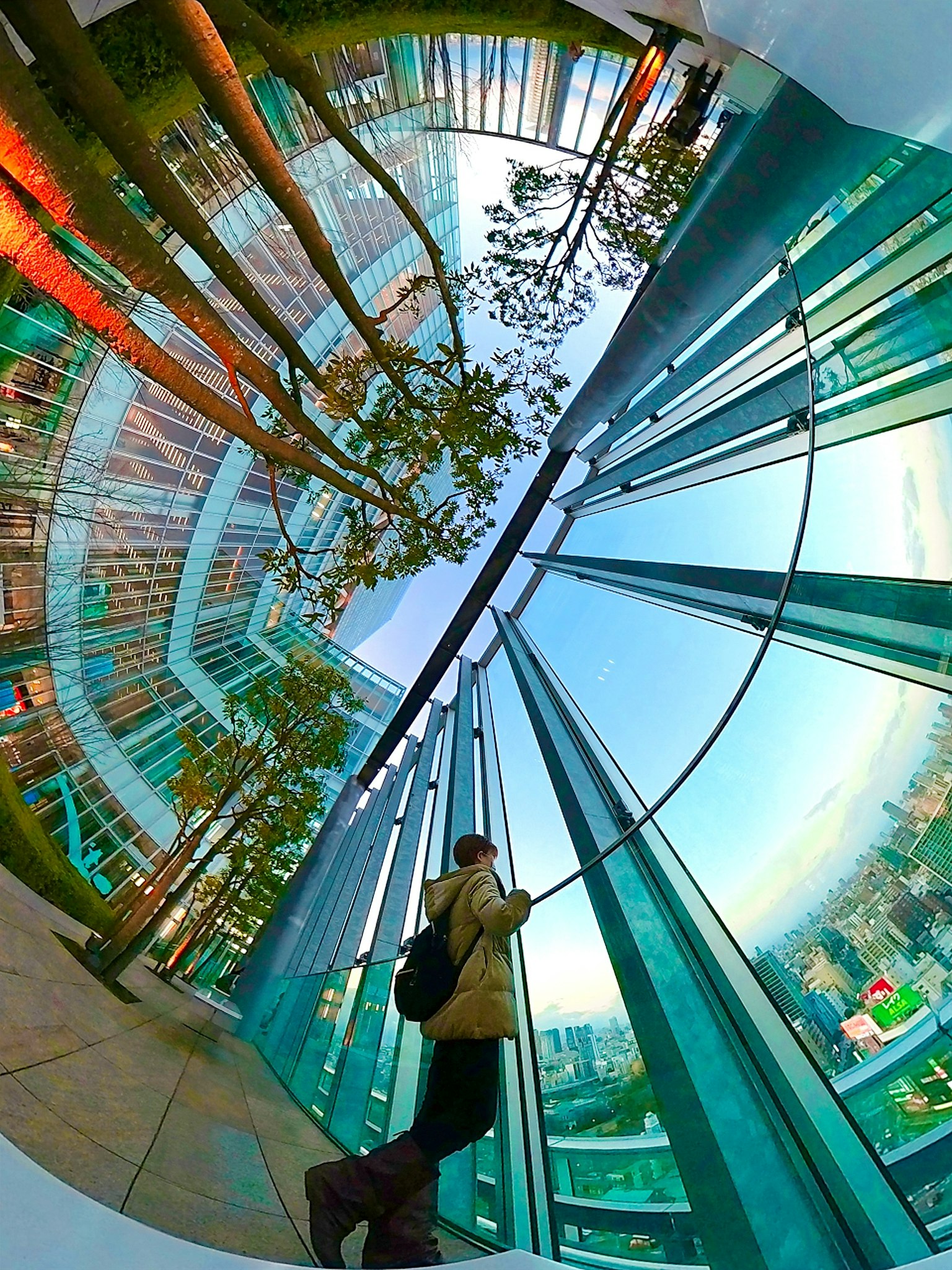 Futuristic space featuring glass buildings and green trees reflected