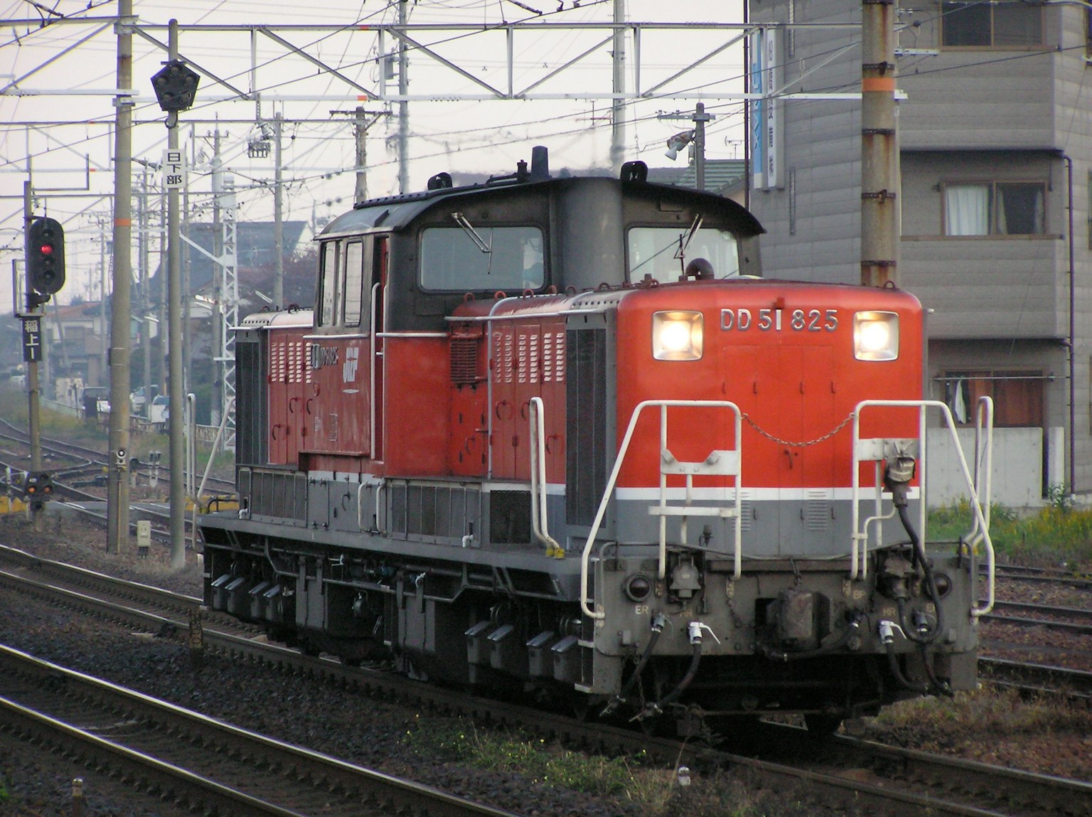 赤いディーゼル機関車が線路に停まっている風景