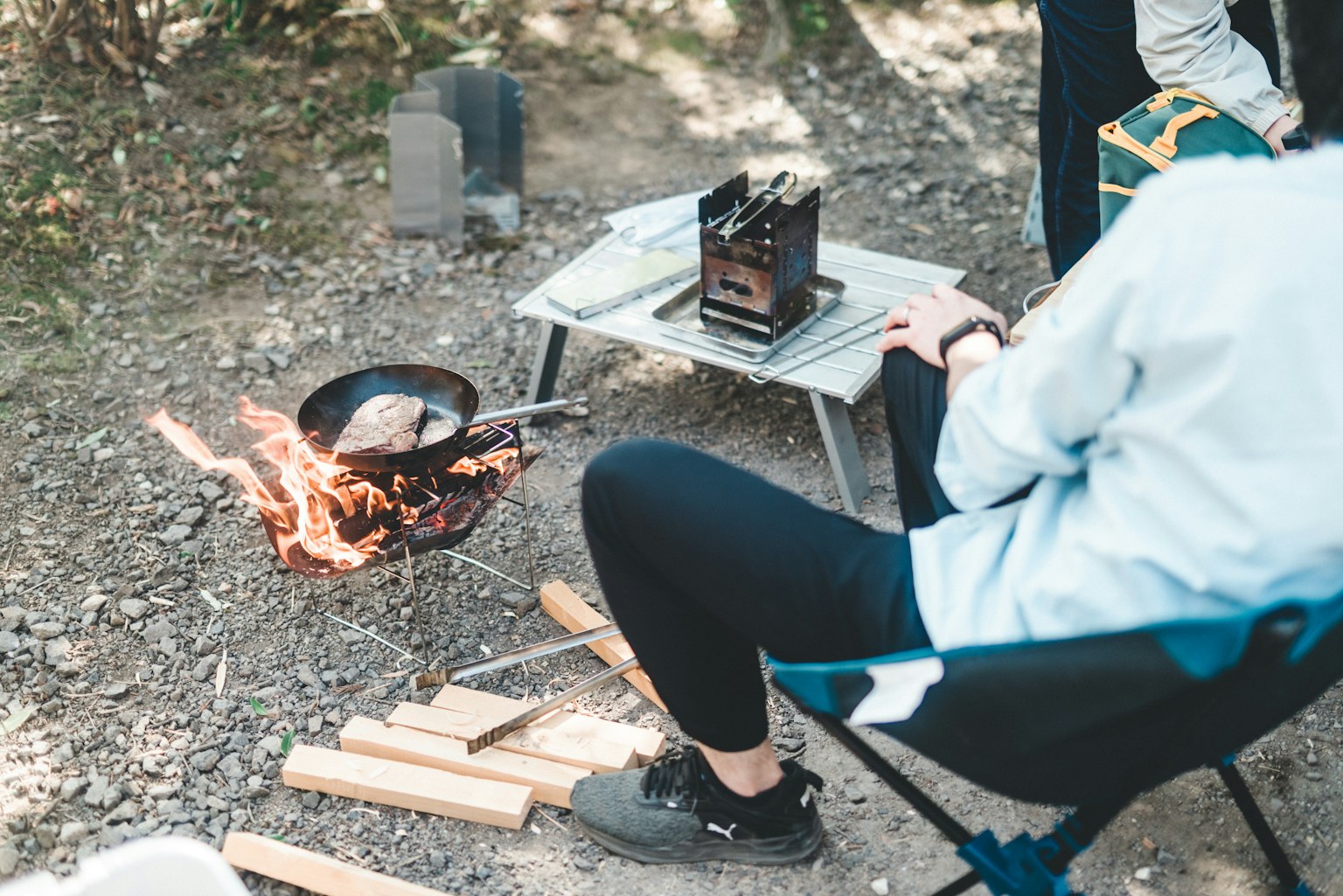 캠핑장에서 요리하는 사람과 휴대용 스토브와 불
