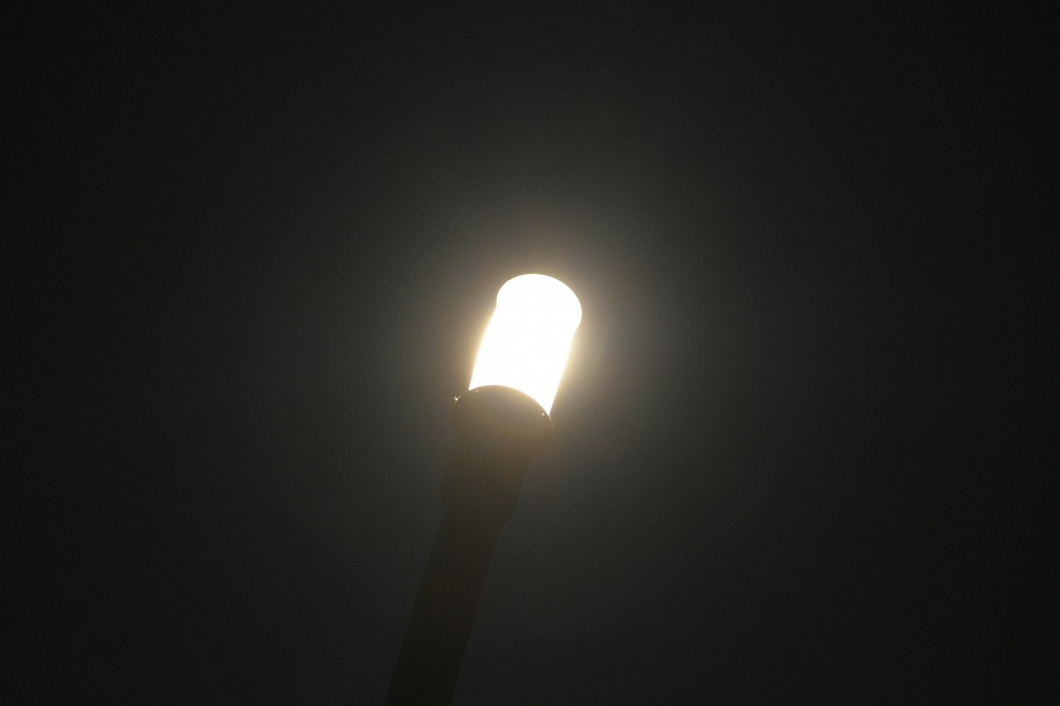 A street lamp glowing brightly in the night