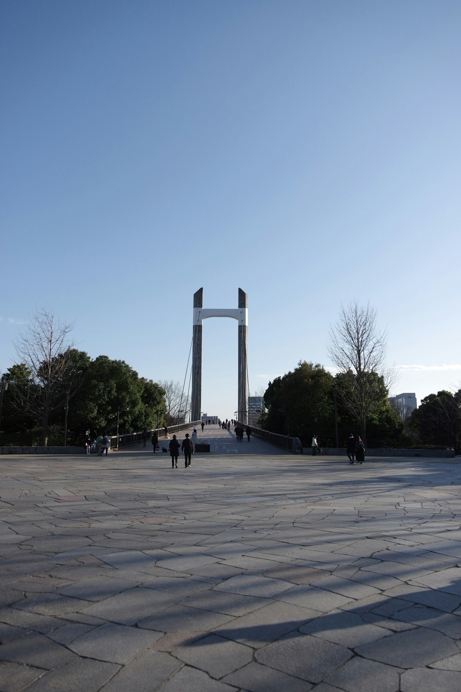 Ponte ad arco sotto un cielo blu chiaro con una grande piazza