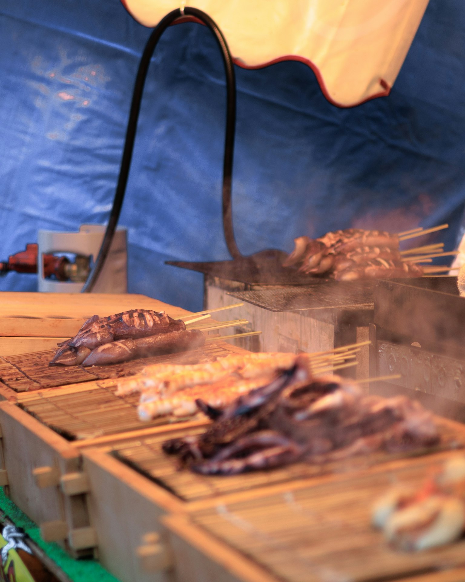 Tusuk sate ikan dan daging yang dipanggang di stan pasar