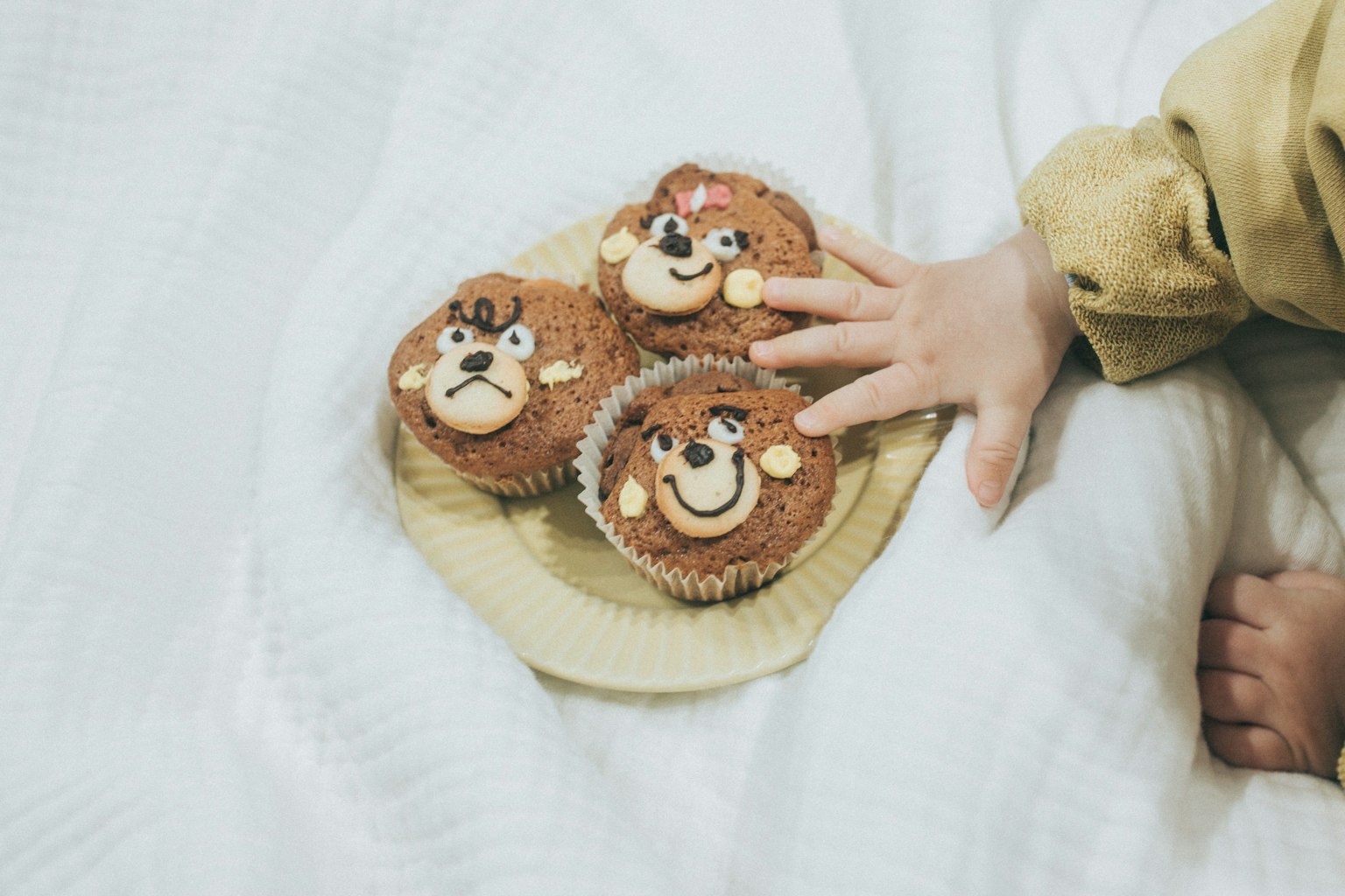 Cupcakes décorés d'ours mignons avec la main d'un enfant qui s'en empare
