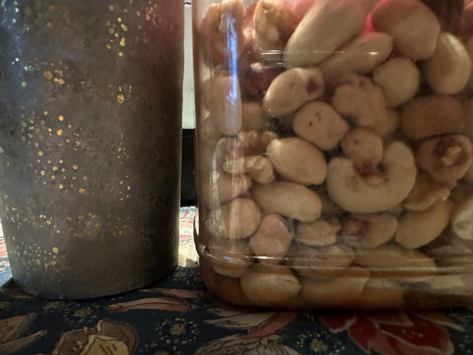 Immagine di noci in un barattolo accanto a una tovaglia decorativa