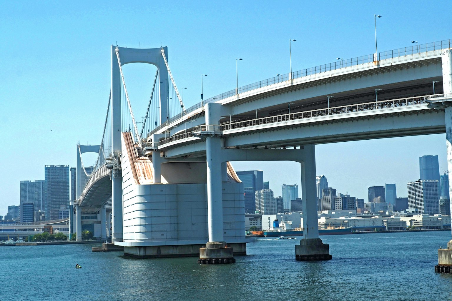Rainbow Bridge structure with urban skyline in the background
