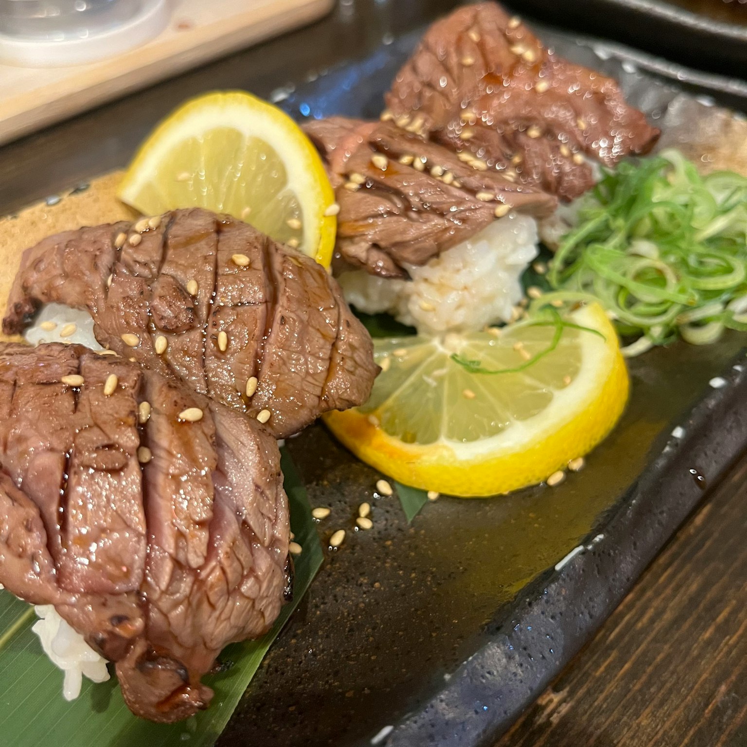 壽司上鋪有切片牛肉，配以檸檬和青蔥