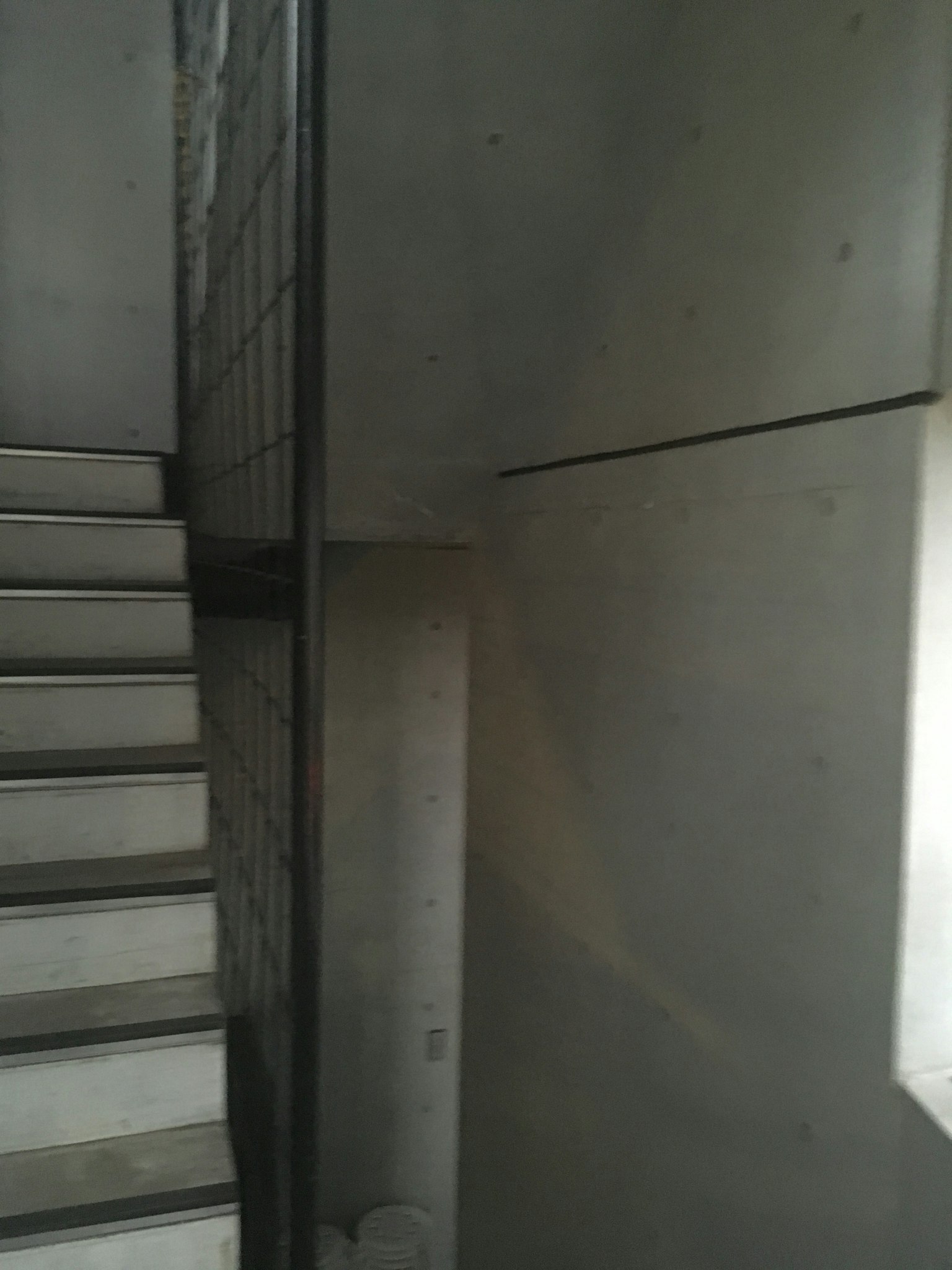 Vue intérieure avec des murs en béton et un escalier