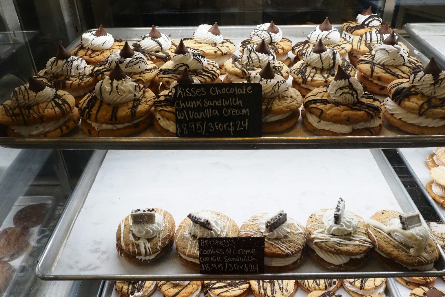 Auslage mit verschiedenen köstlichen Desserts, garniert mit Sahne und Schokolade