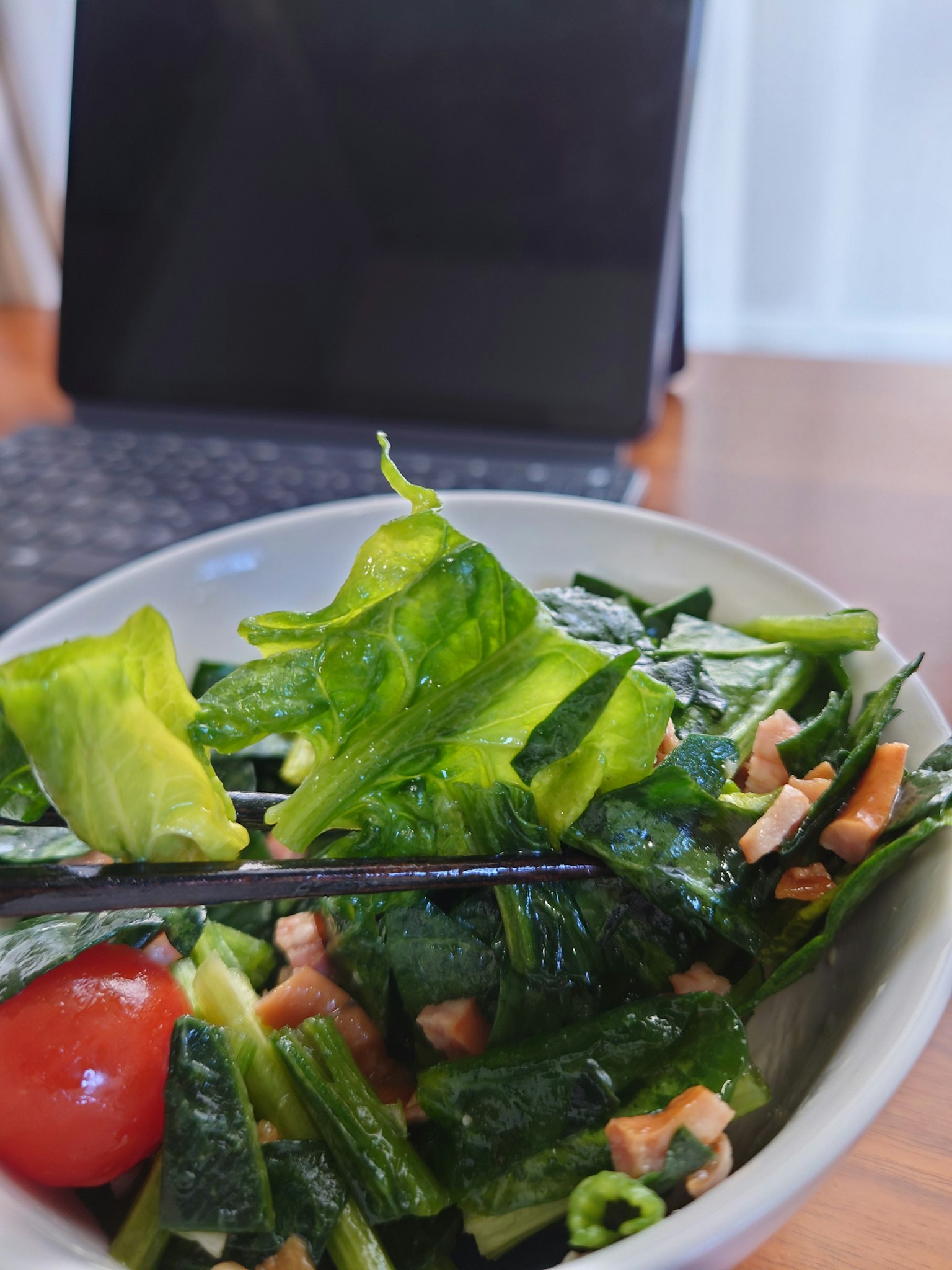 Una ciotola di insalata con verdure a foglia verde e pomodorini