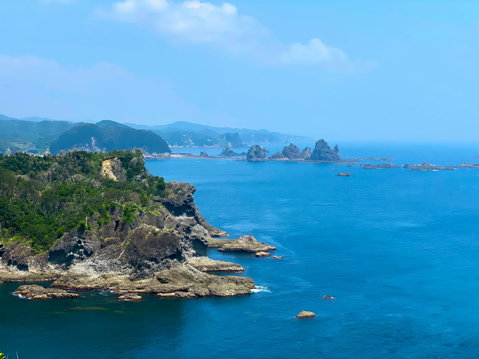 Pemandangan laut biru dan garis pantai berbatu