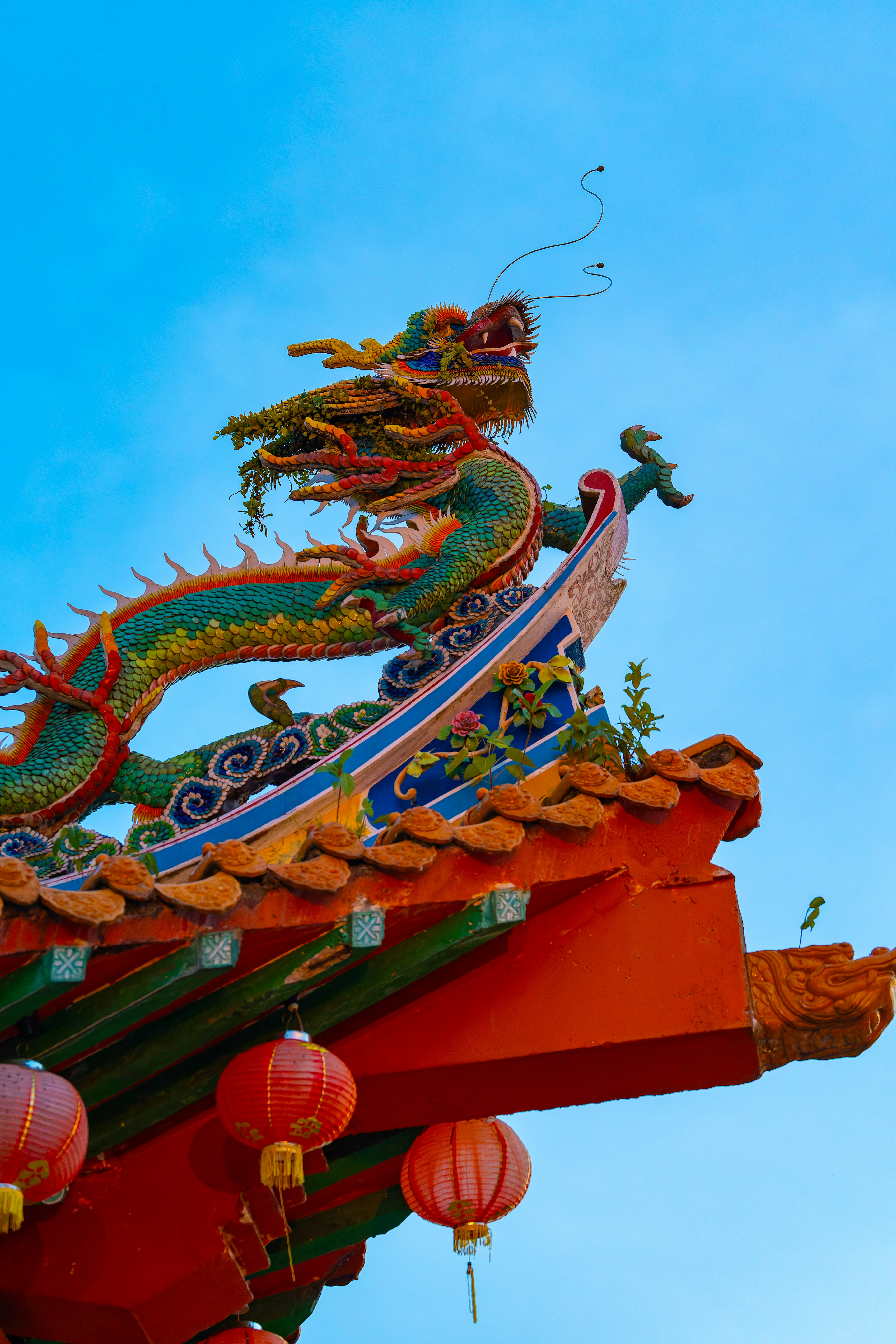 upper part of a red roof building with dragon decorations
