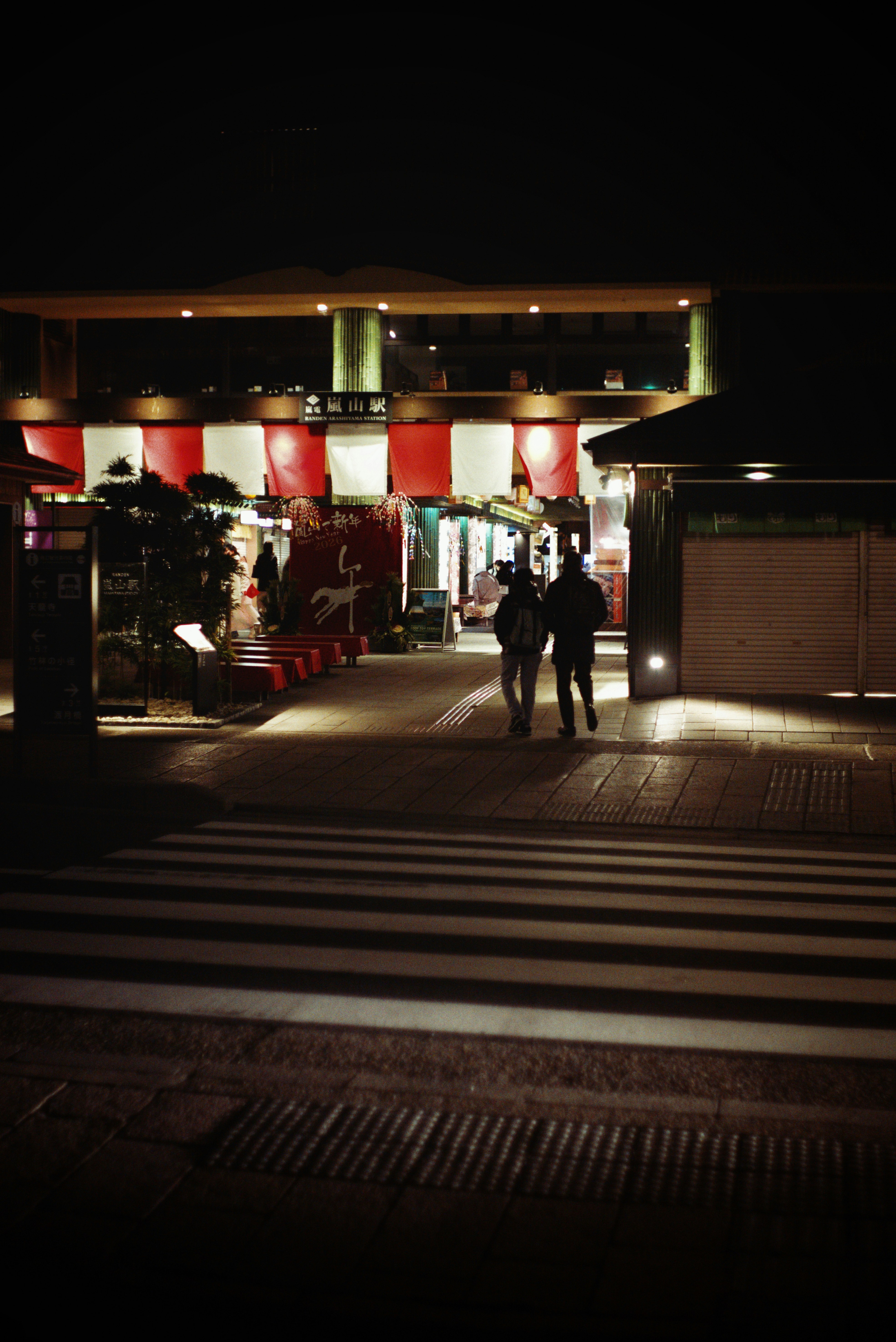嵐山の夜の路地に灯る提灯と人影の新年風景
