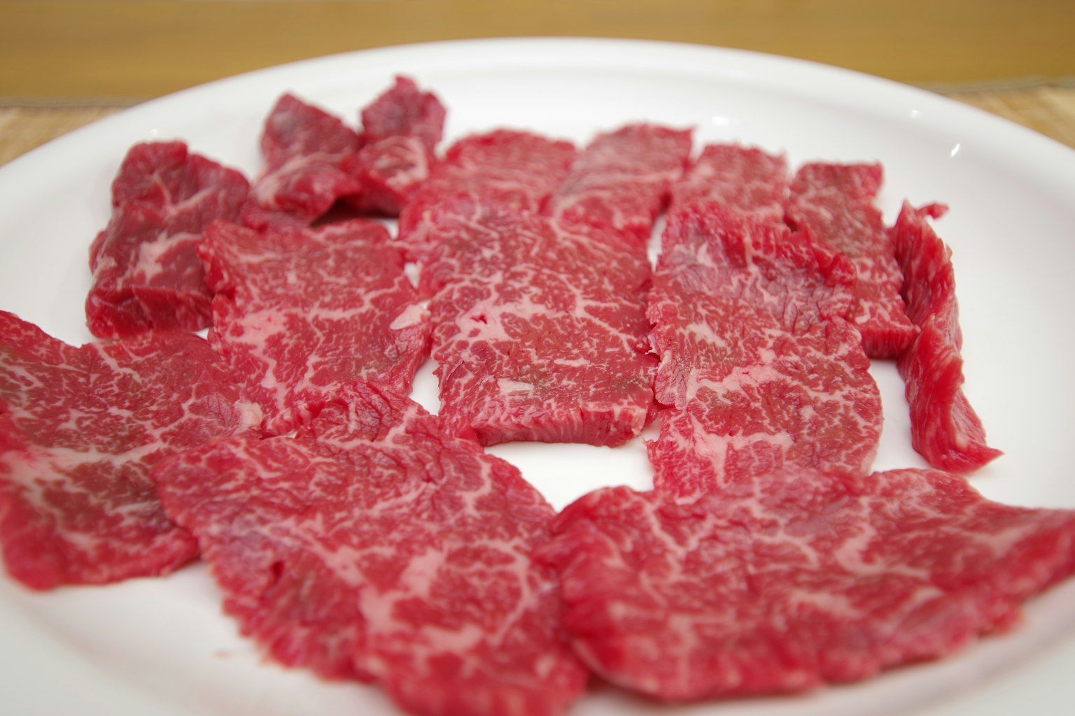 Daging Wagyu tipis disusun di atas piring putih