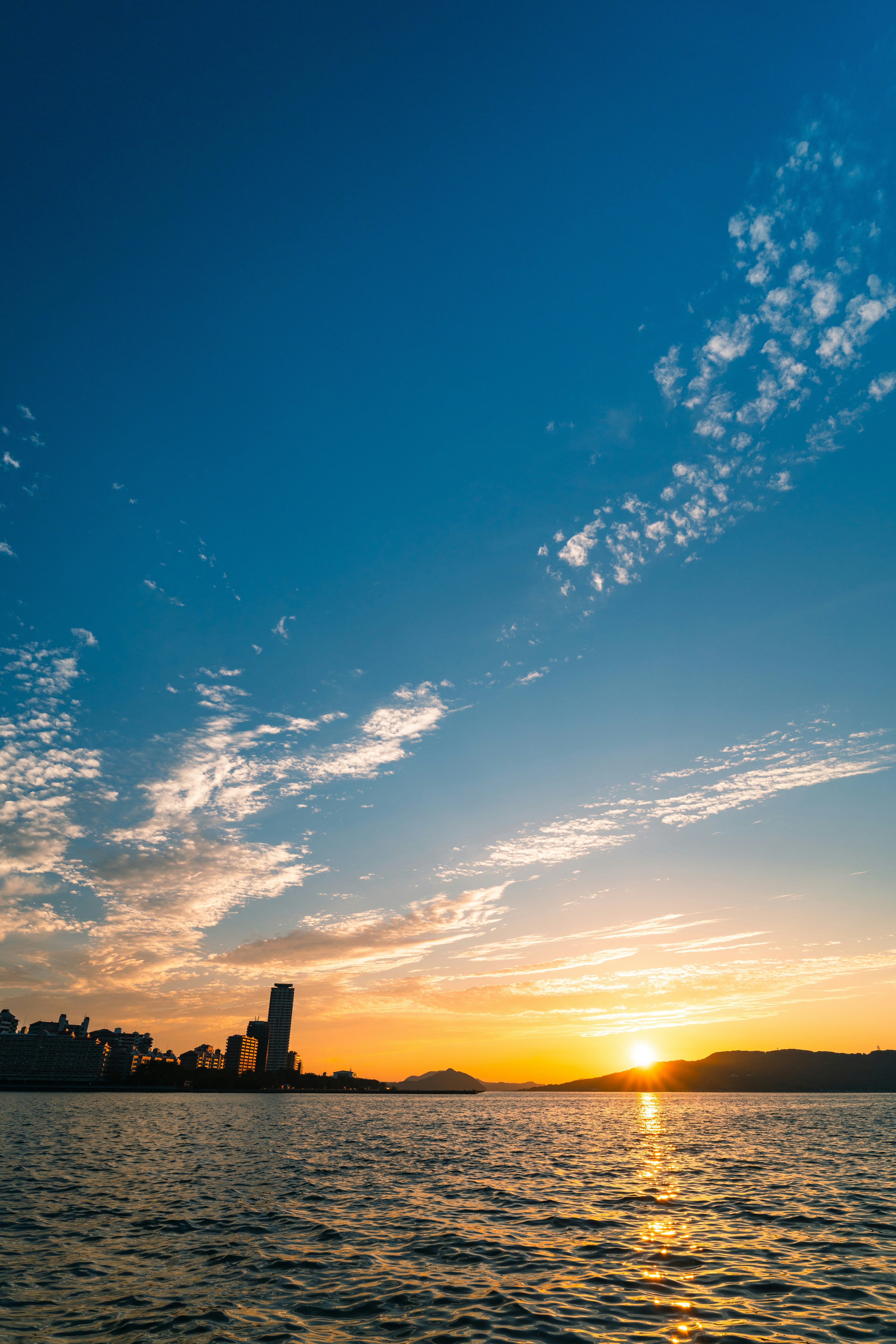 夕日に照らされる海面と水平線の風景