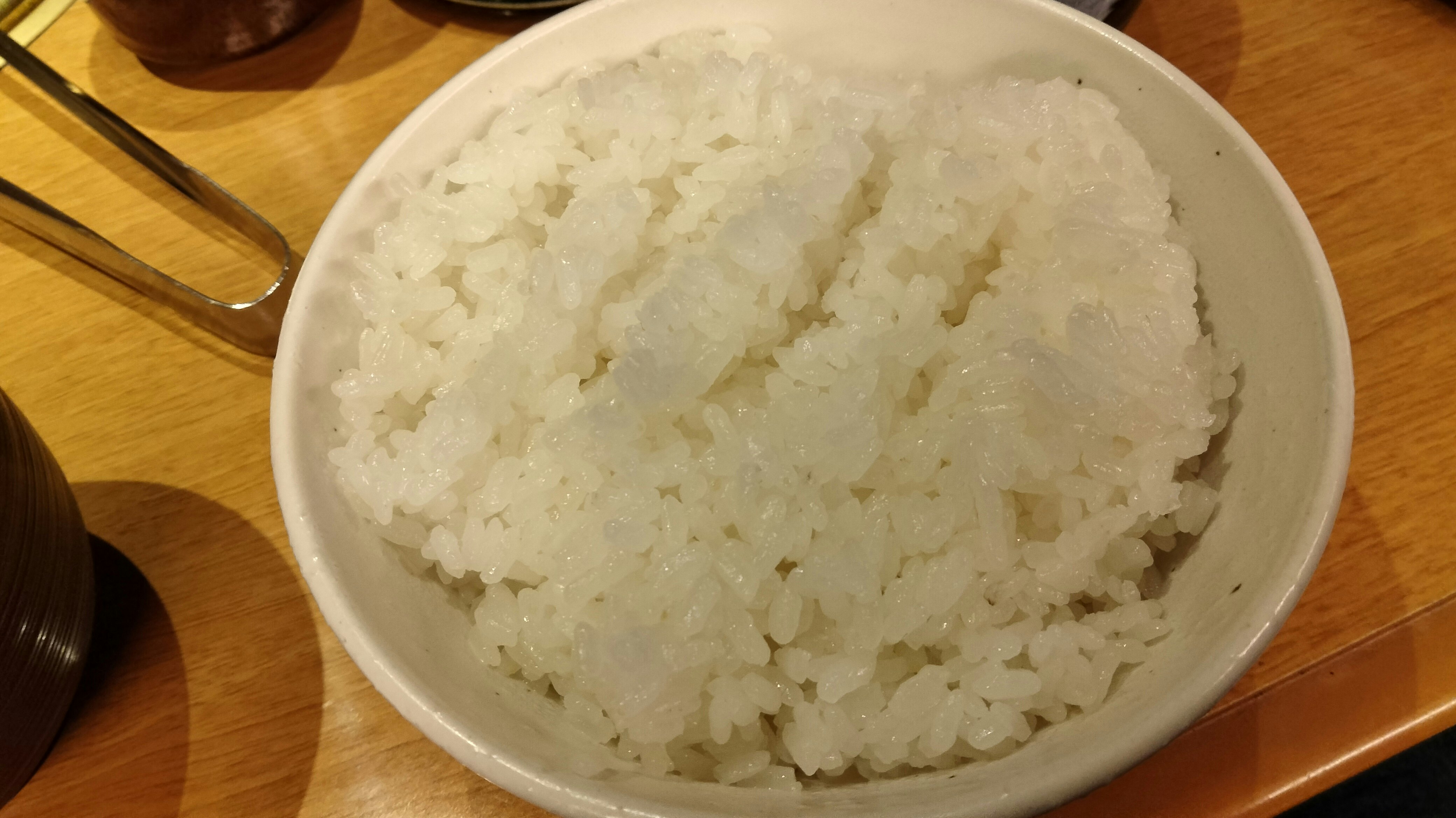 木のテーブル上の白いご飯のボウル