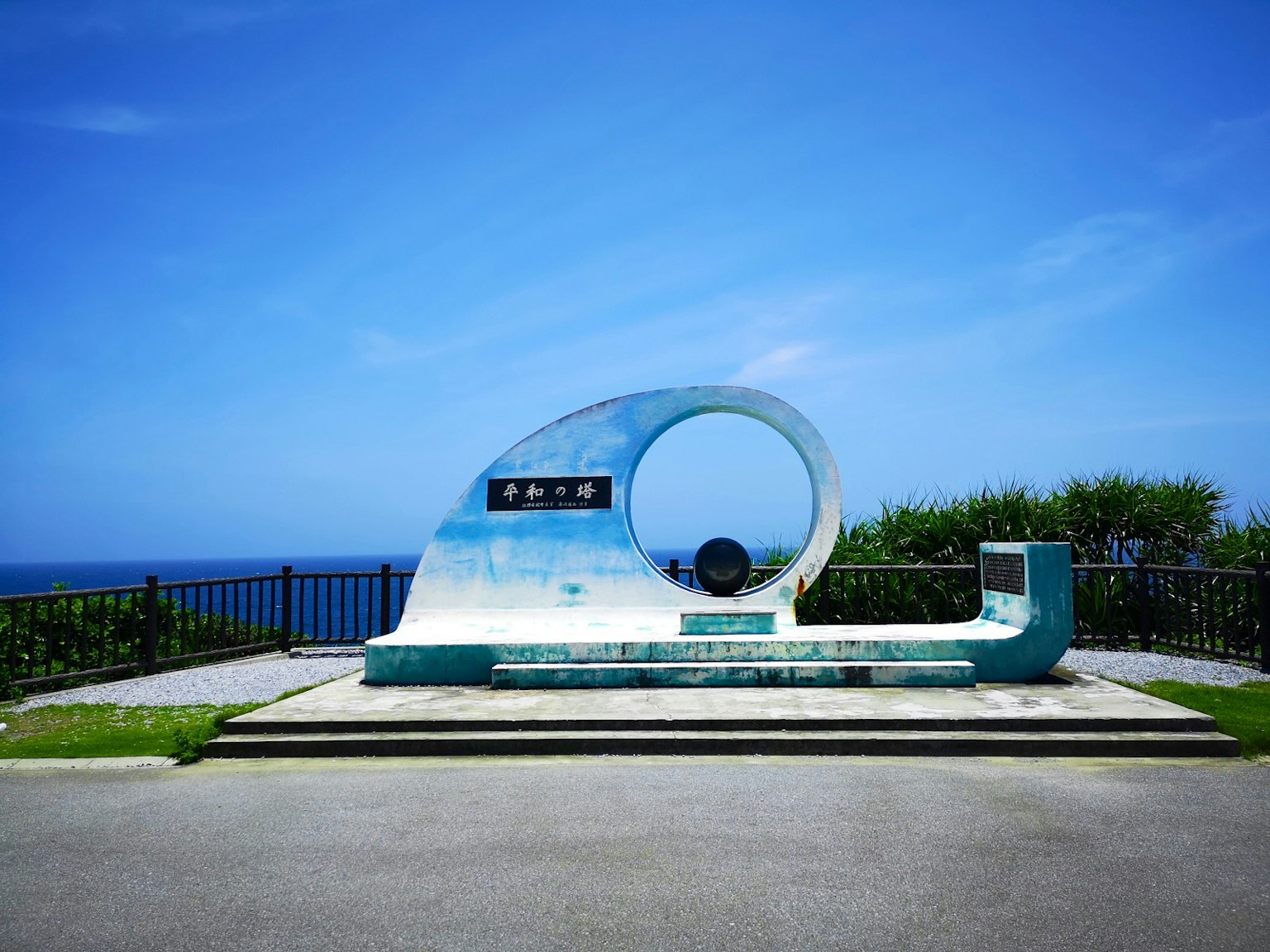 Monumen unik di bawah langit biru dengan pemandangan laut