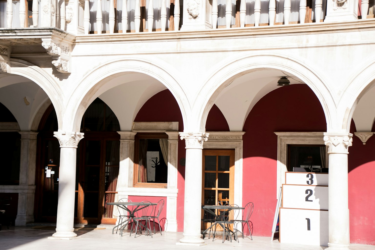 Exterior de edificio con columnas en arco y pared roja