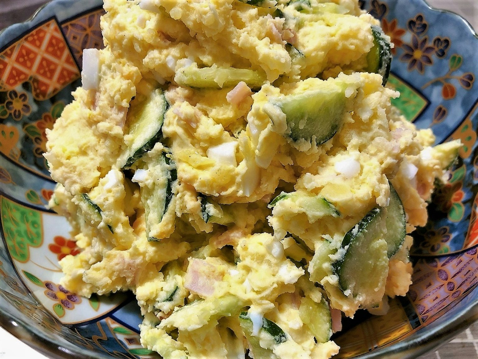 A photo of potato salad served in a vibrant bowl