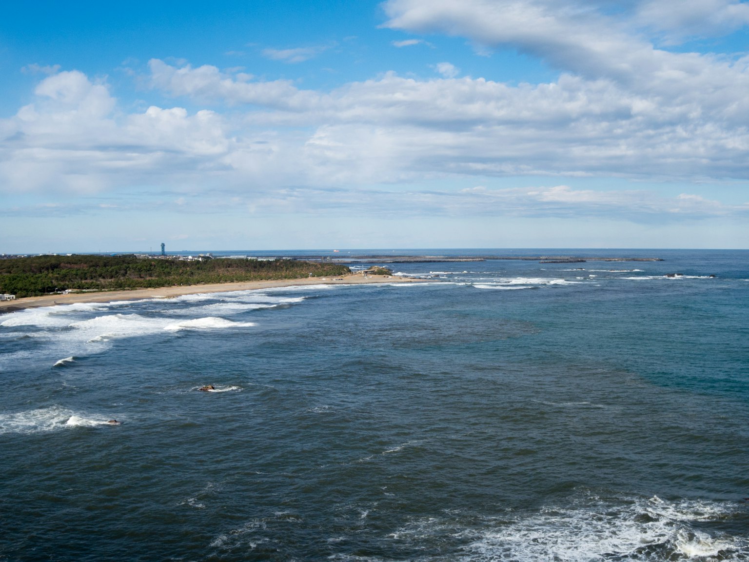 Scenic view of blue ocean with white waves coastline and blue sky