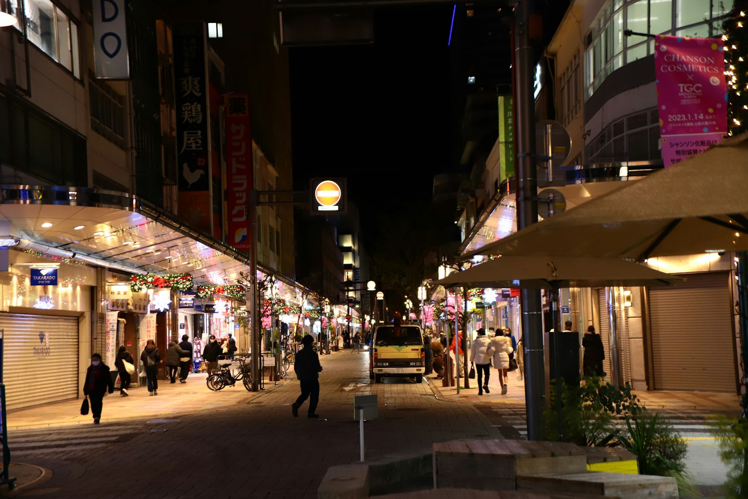 夜間街景有人走動和明亮的招牌