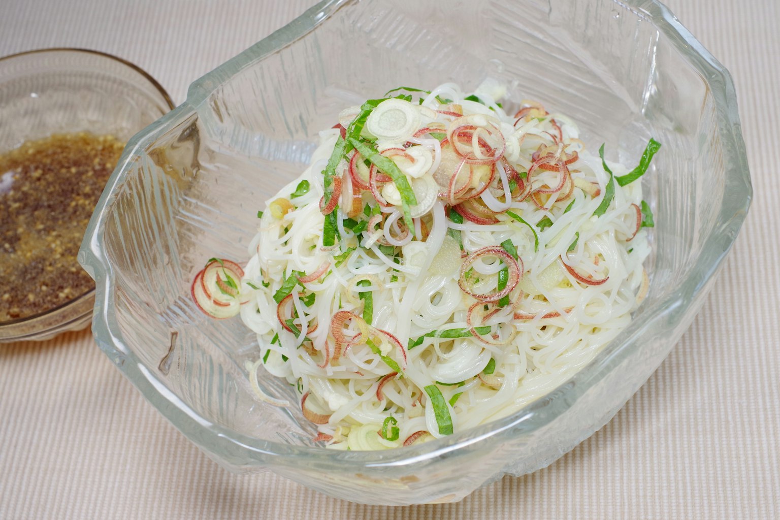 Salad mie dingin dengan udang disajikan dalam mangkuk kaca bening