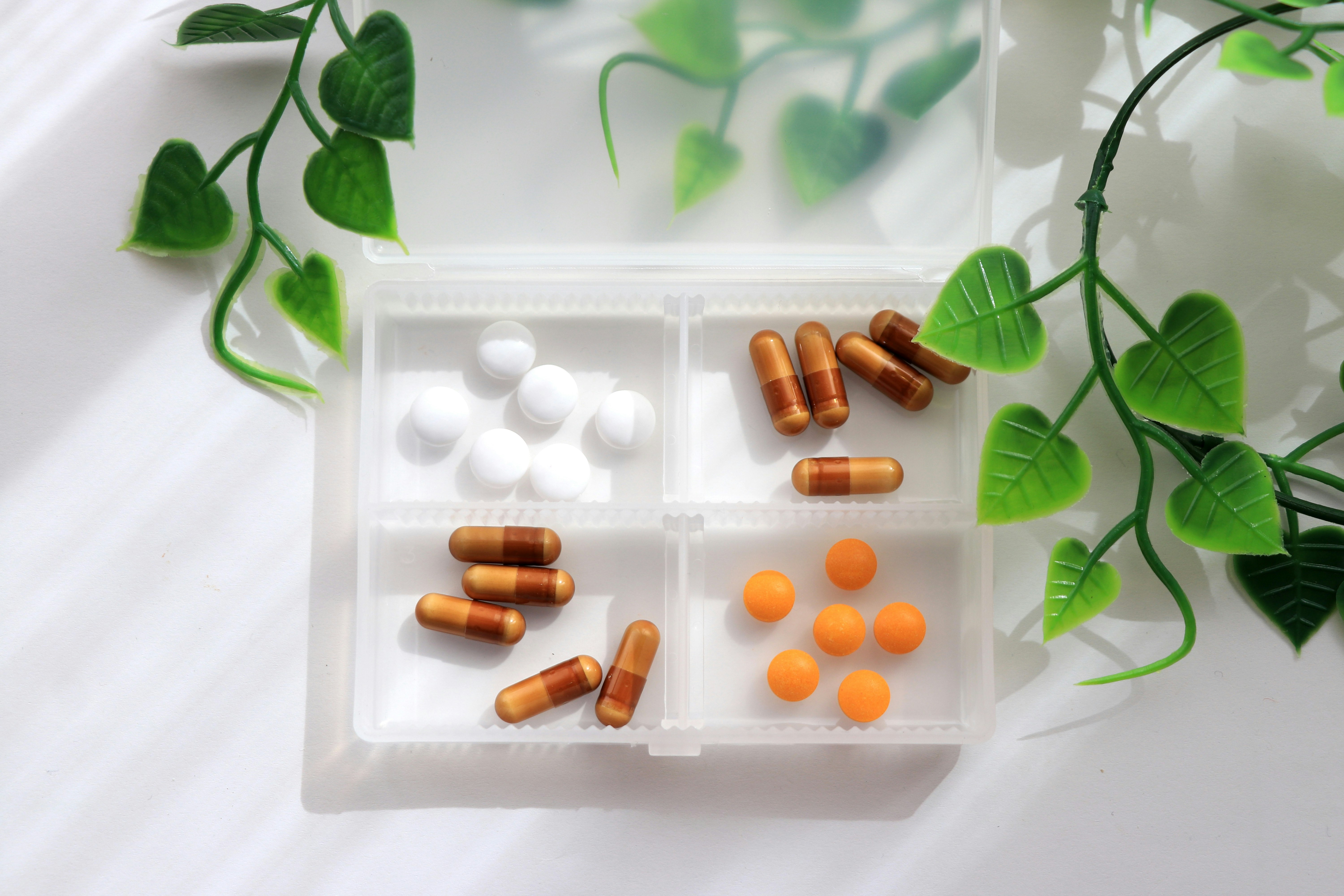 cápsulas y tabletas de suplementos dispuestas en una bandeja blanca