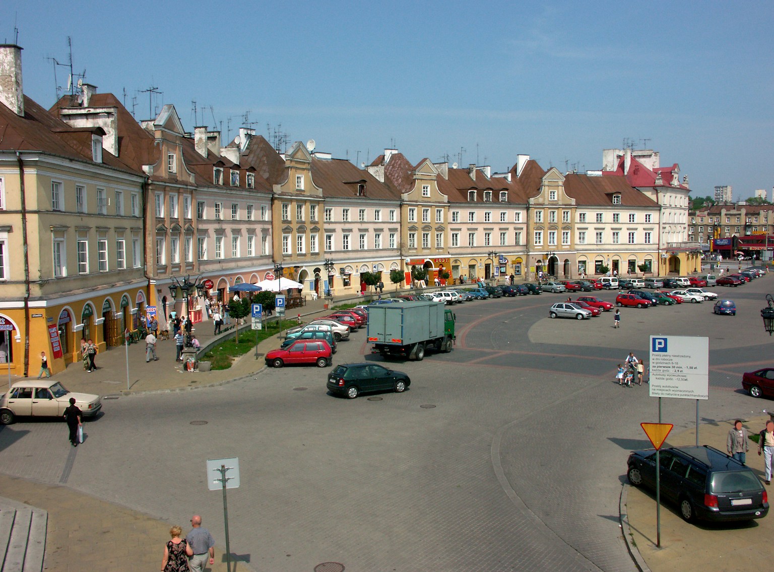 一個生動的廣場，有色彩斑斓的建築和停放的汽車