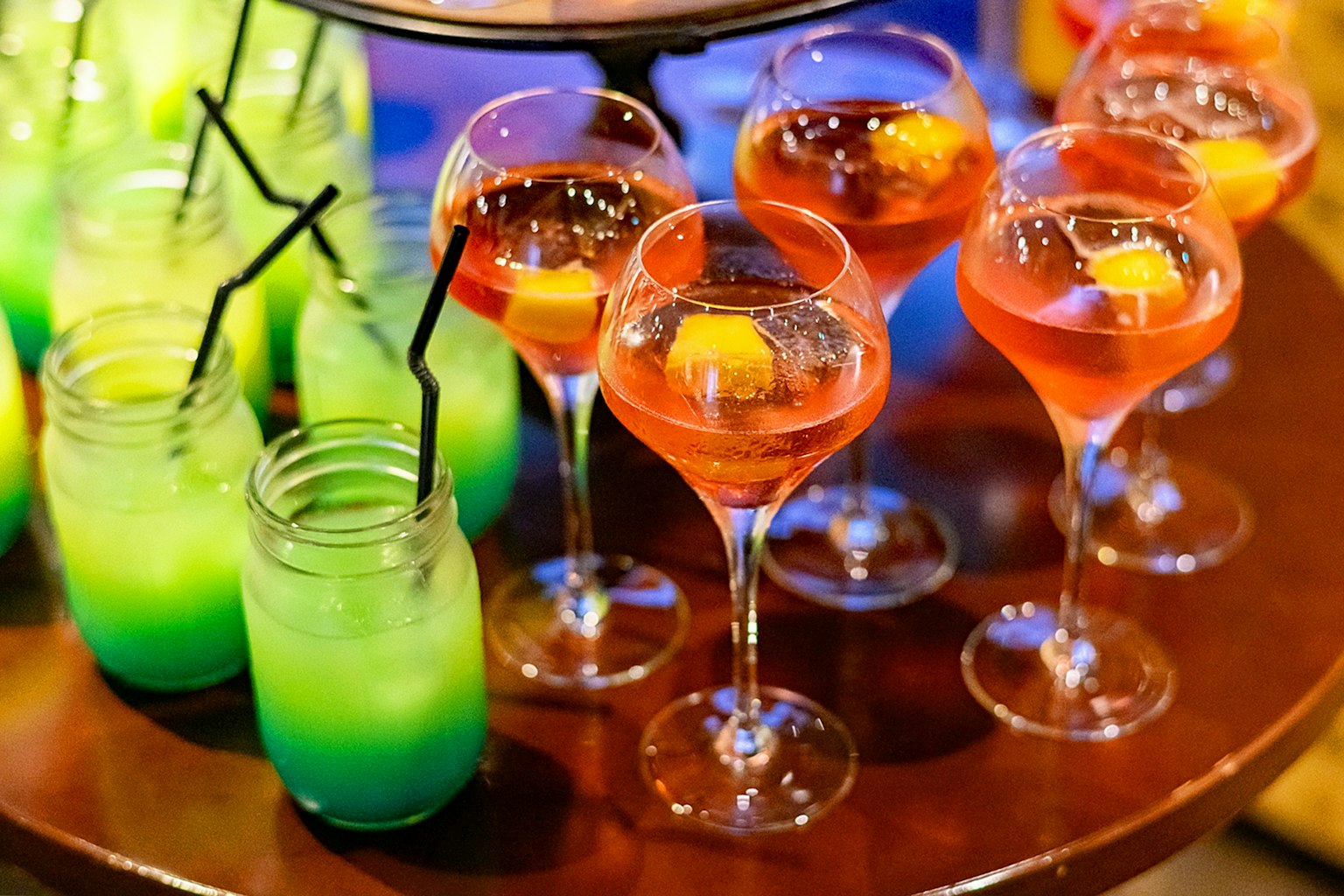 Cócteles coloridos dispuestos en una mesa de bar