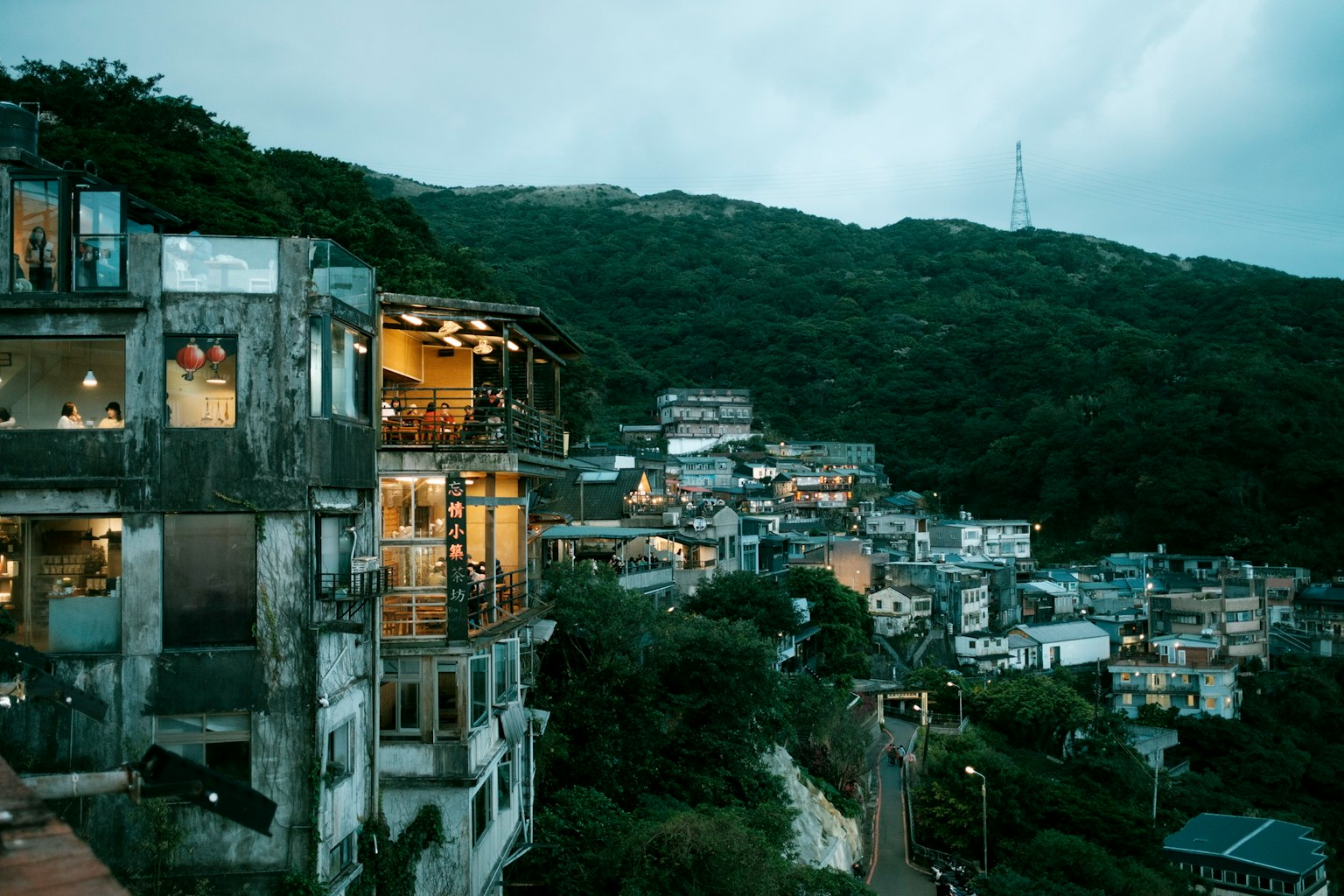Night view of a hillside residential area featuring a mix of old and new buildings
