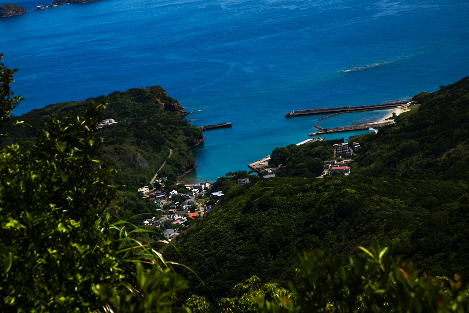 青い海と緑の山々に囲まれた小さな町の風景
