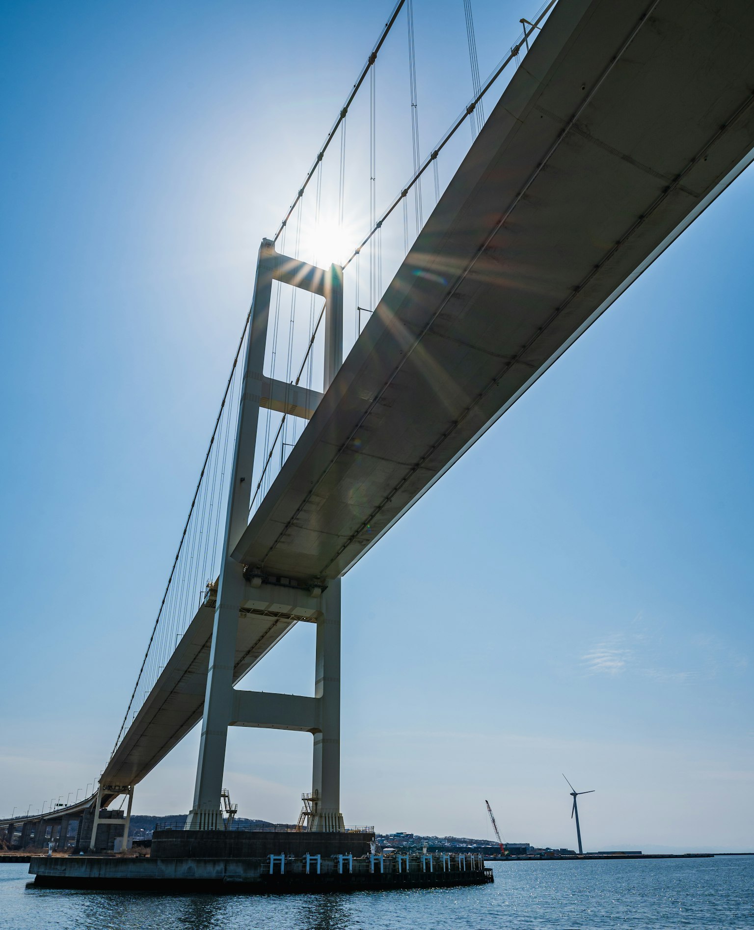 View of a bridge from underneath with sunlight shining