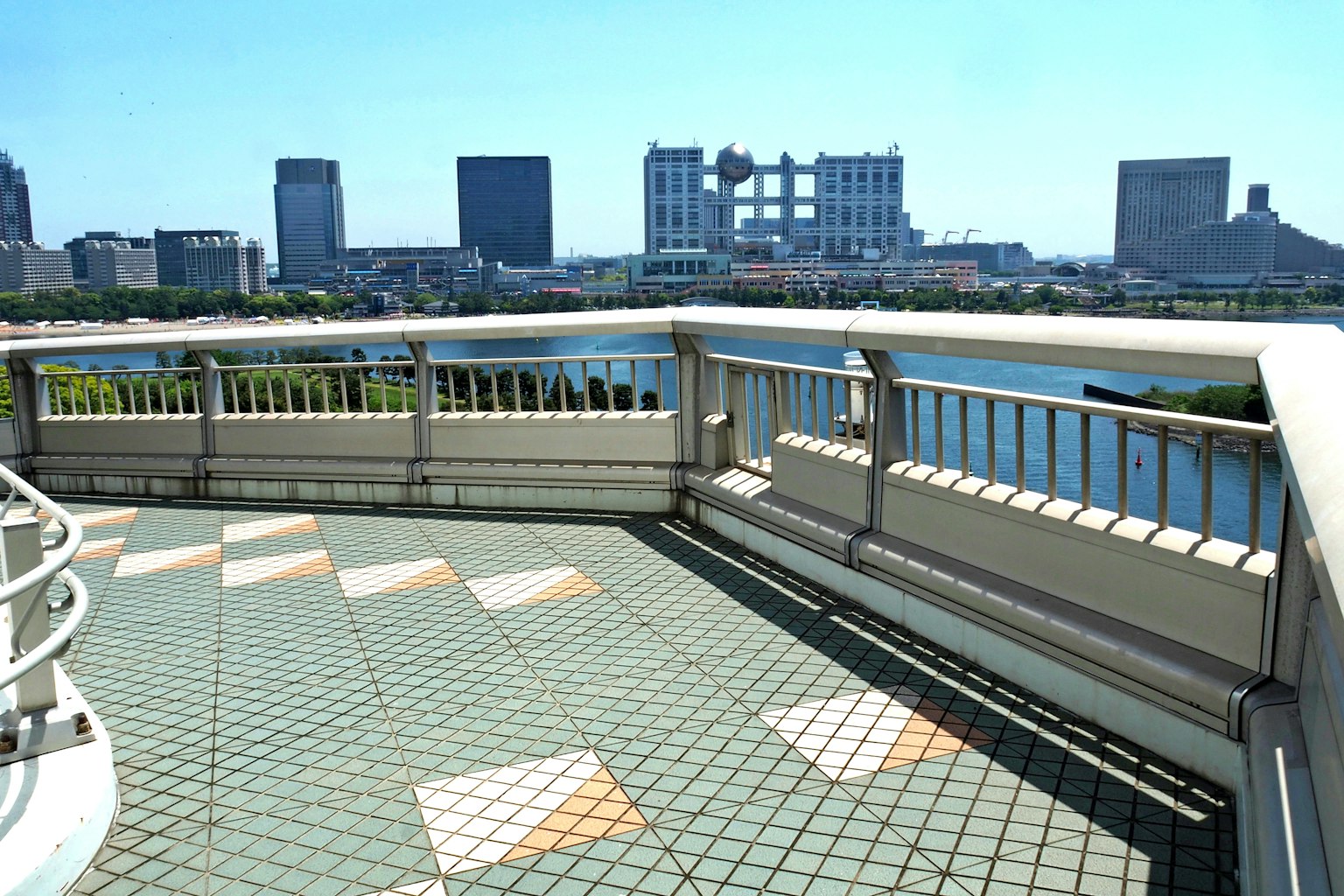 Vue de balcon sur une ligne d'horizon urbaine sous un ciel bleu clair