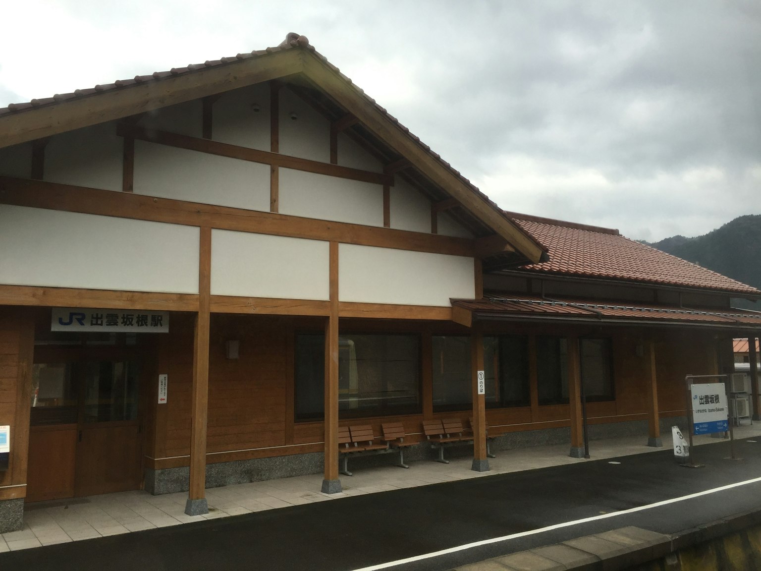 木質火車站外觀，帶有傾斜屋頂和座椅區