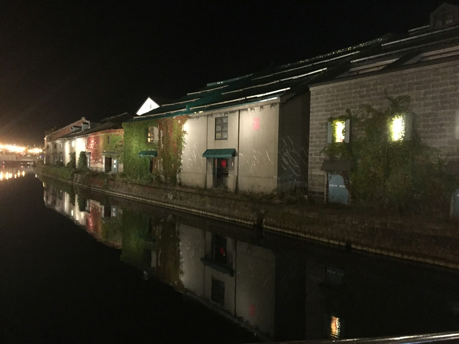 Edificios históricos a lo largo de un canal de noche con reflejos