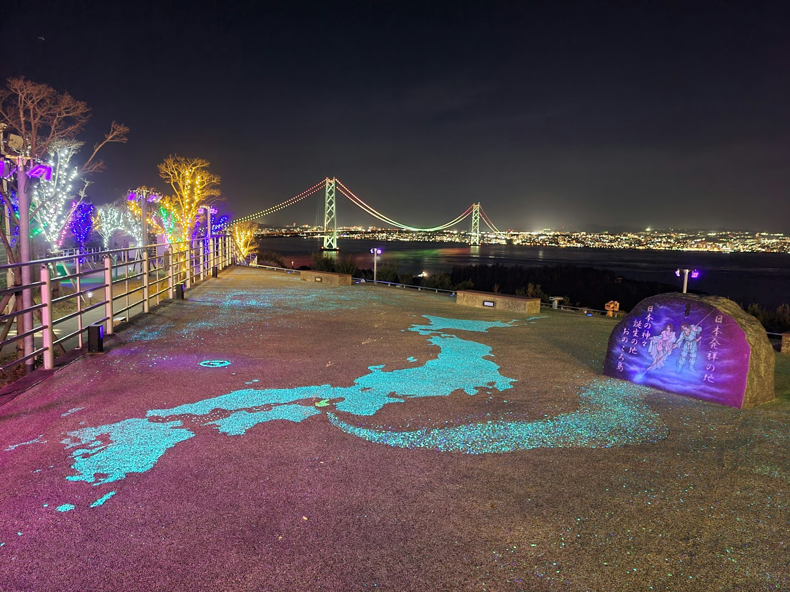 Mappa del Giappone illuminata proiettata a terra con un ponte sullo sfondo di notte