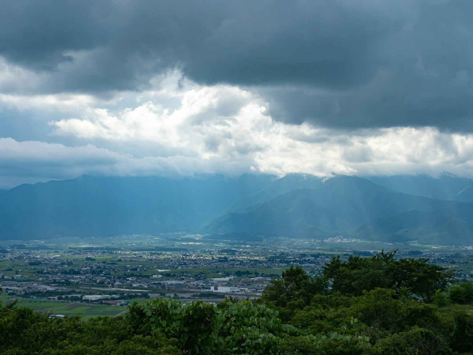Vista escénica de montañas y nubes con luz solar