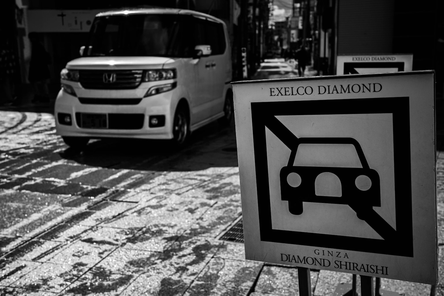 Pemandangan jalan dengan mobil putih dan tanda larangan parkir