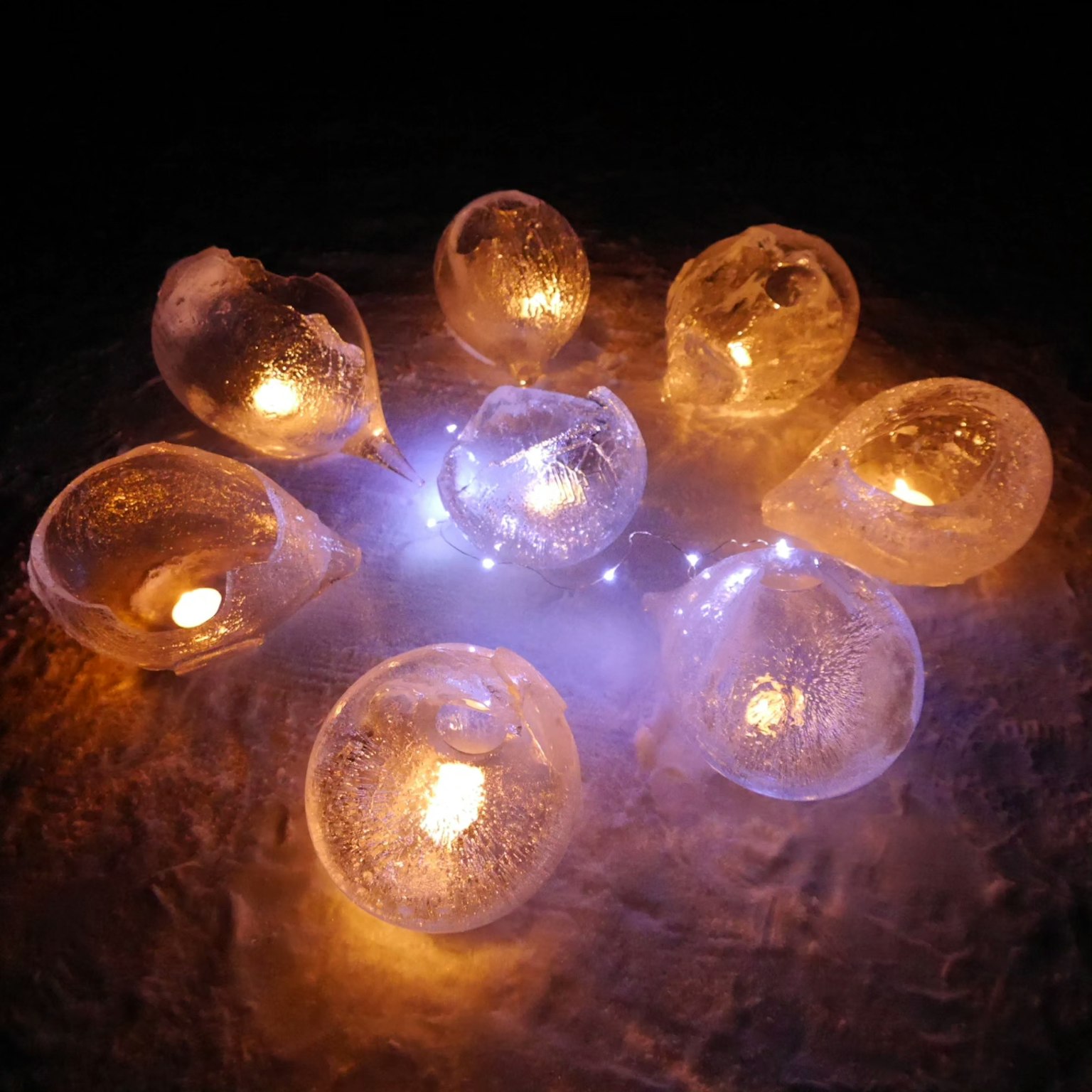 Candele in portacandele simili al ghiaccio che galleggiano sull'acqua
