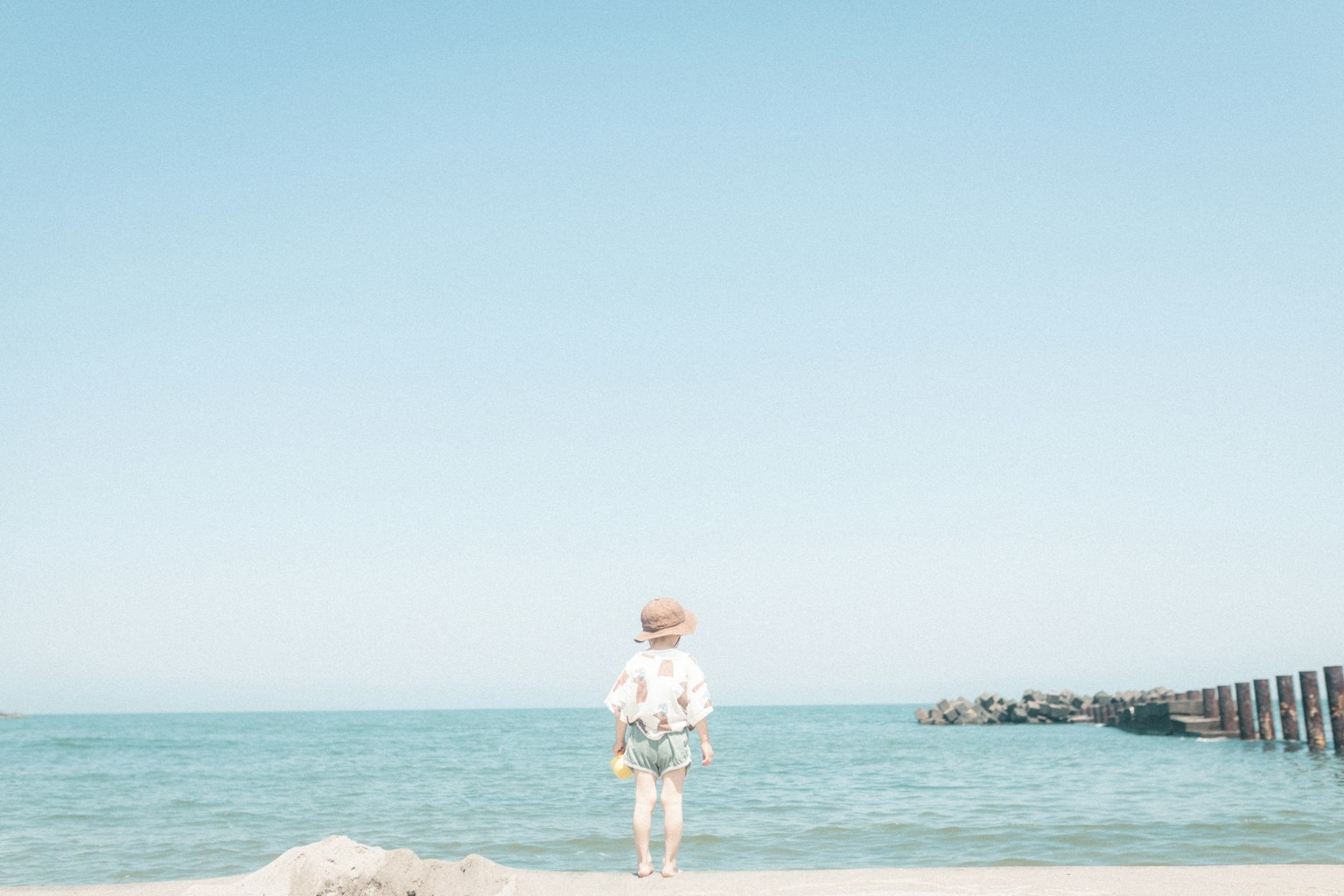 Personne sur la plage faisant face à l'océan ciel bleu clair