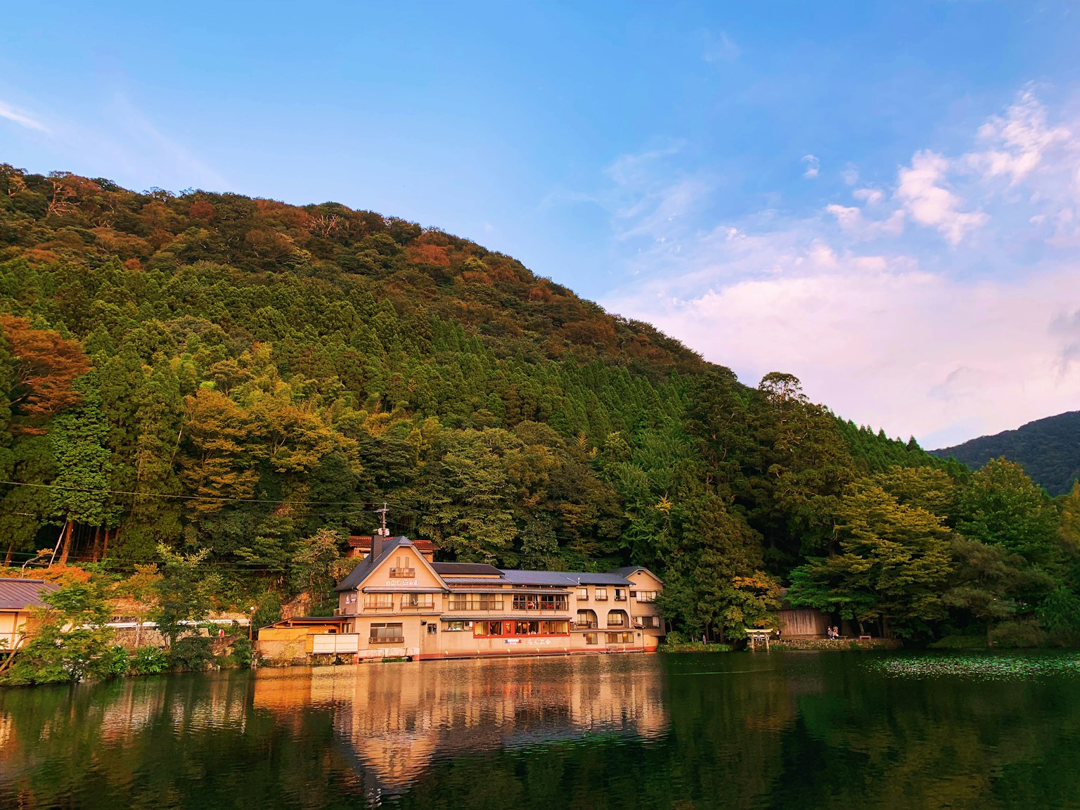 湖邊住宿被郁郁蔥蔥的山脈環繞，映襯著落日的天空