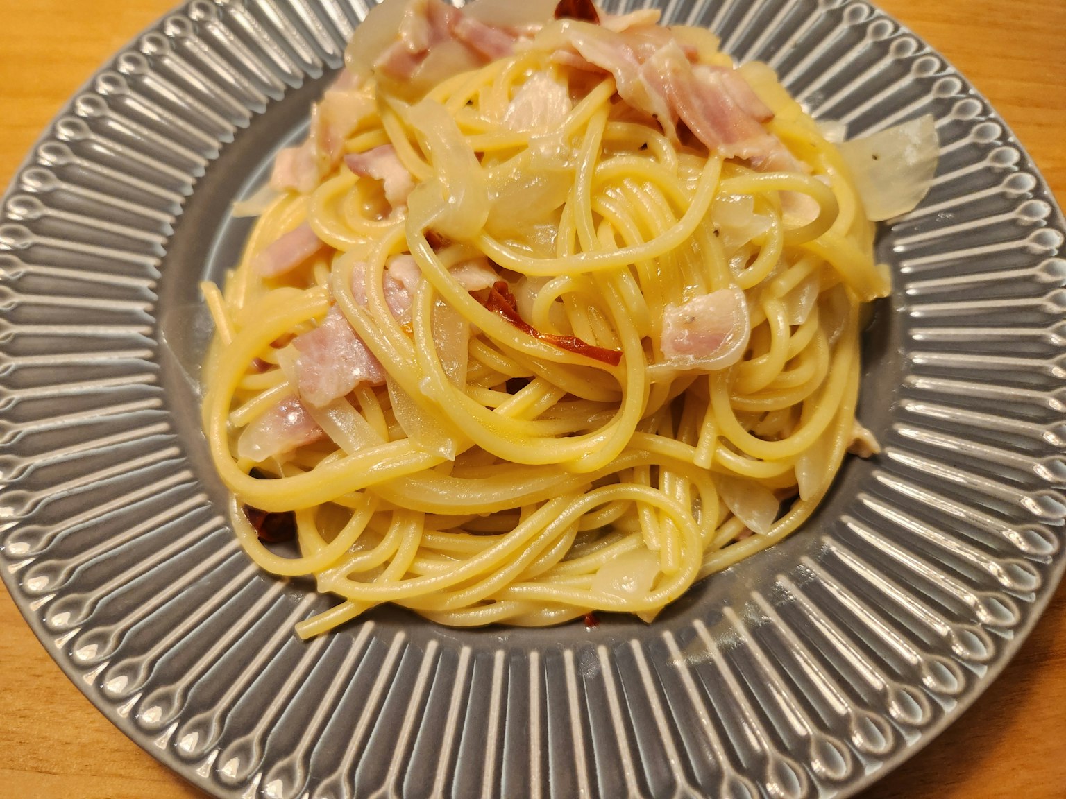 Teller mit Spaghetti, Schinken und Zwiebeln schön angerichtet