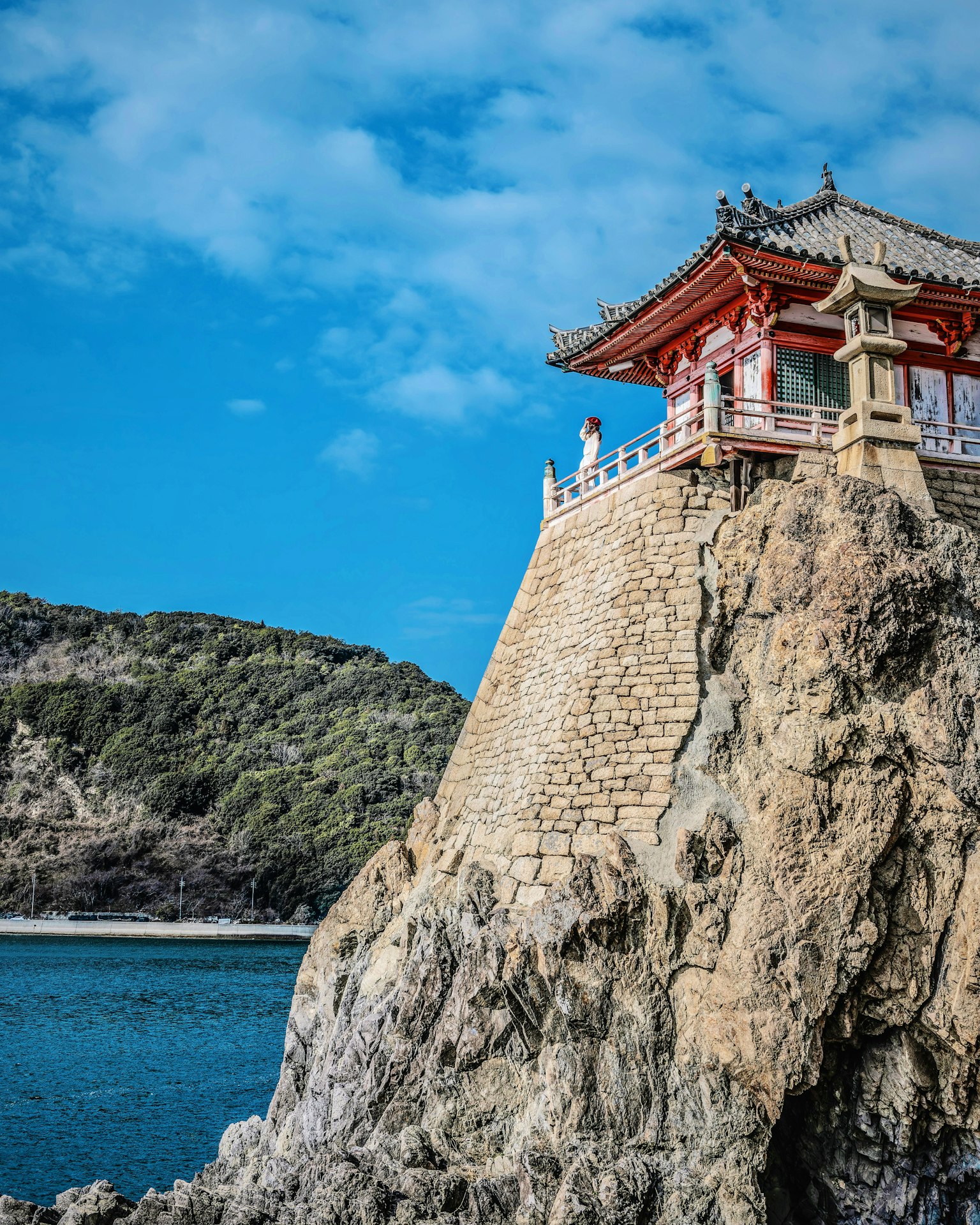 传统建筑坐落在岩石悬崖上,蓝天和海洋的美丽景色