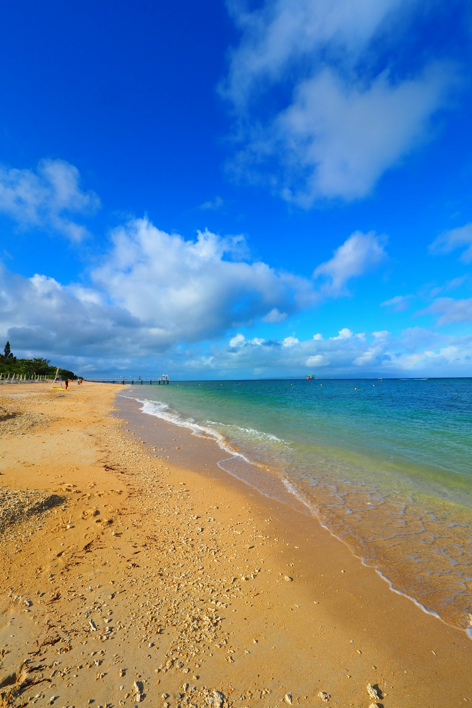 Scenic beach view with blue sky and gentle waves