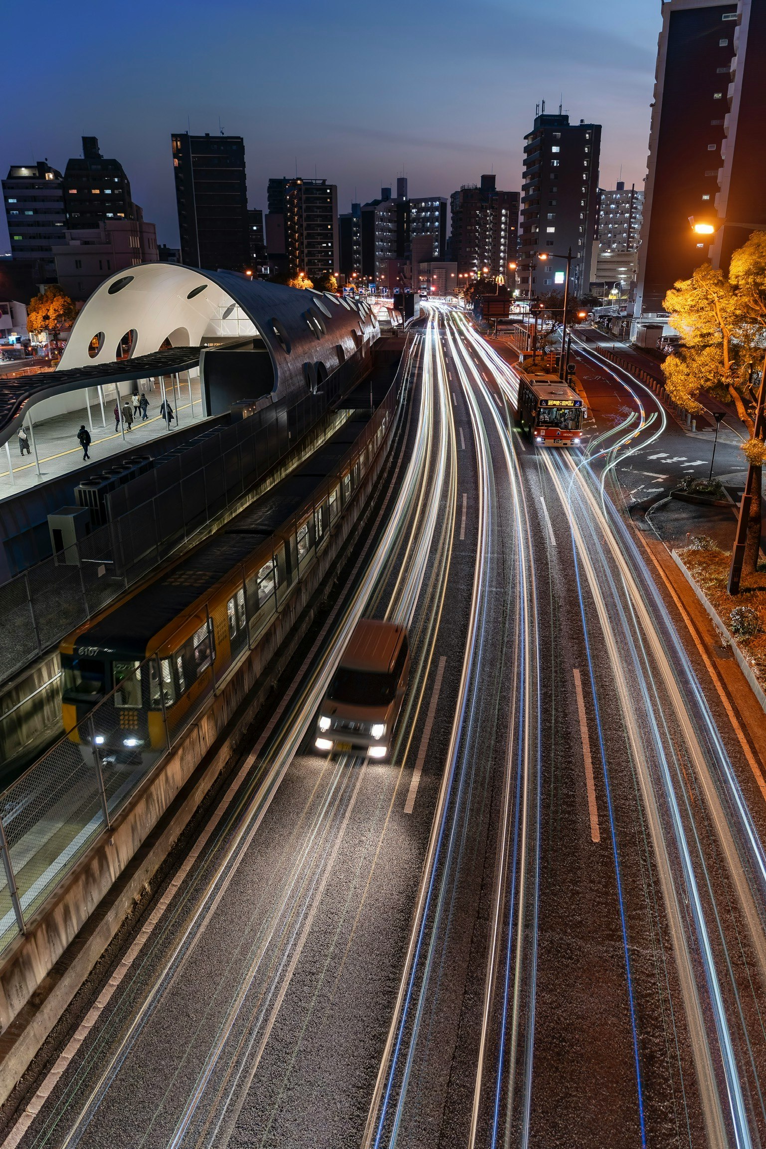 Paysage urbain nocturne avec des voies ferrées et des bâtiments illuminés